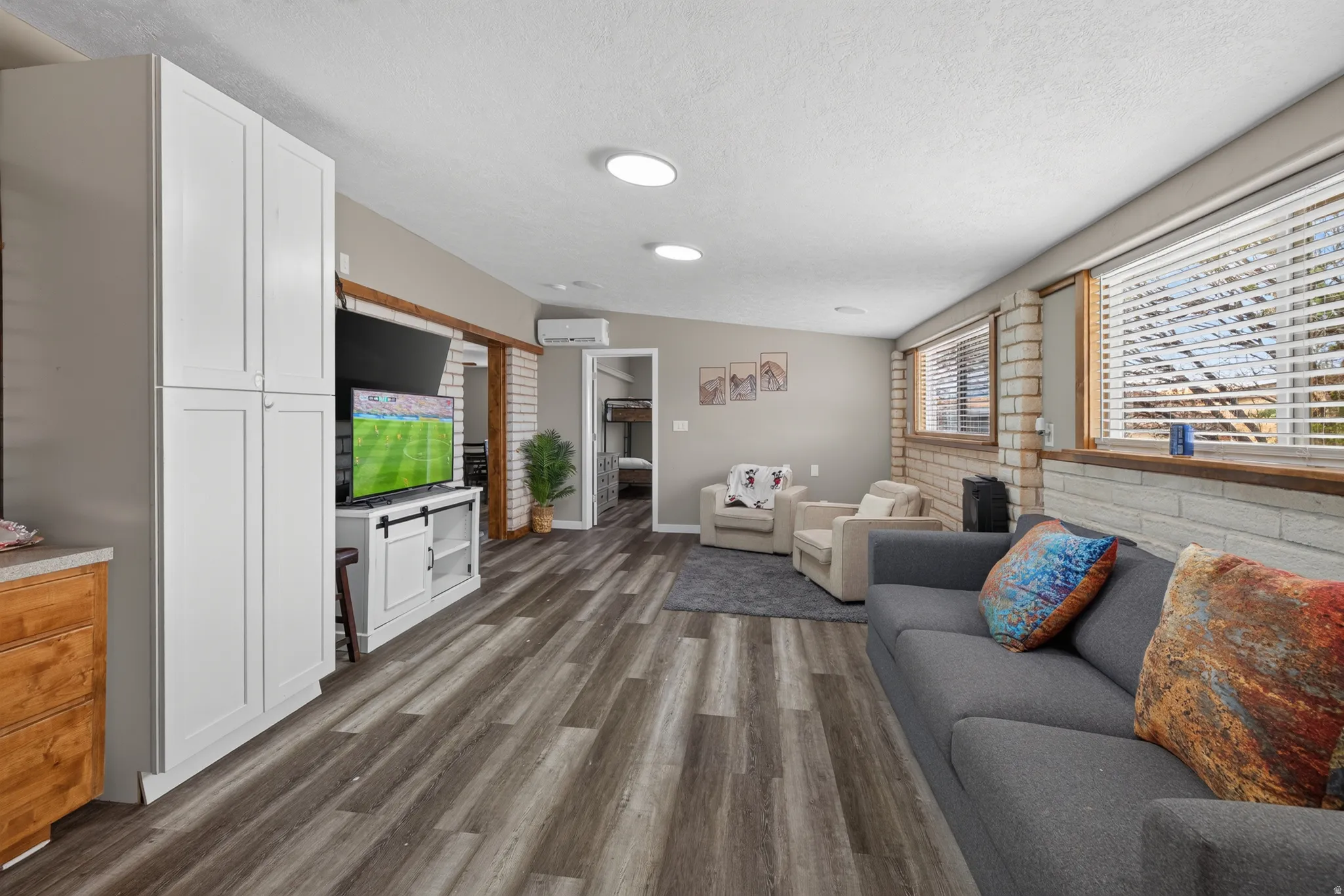 Spacious room featuring wood-finish flooring, recessed lighting, and white built-in cabinetry
