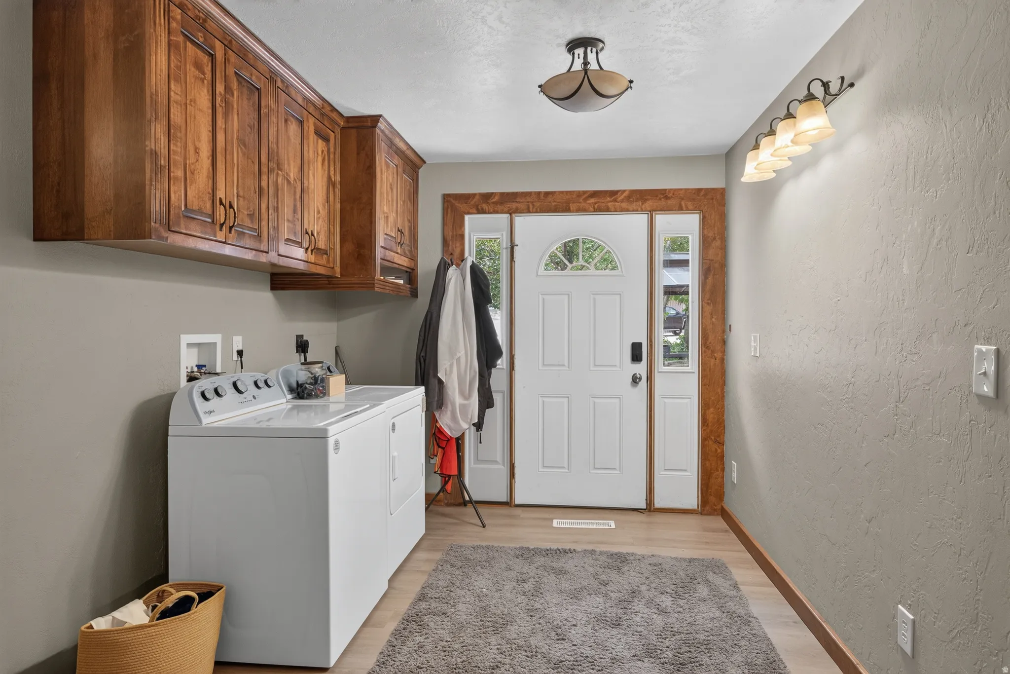 Entryway with light wood-finish flooring and a white paneled door with an arched transom window