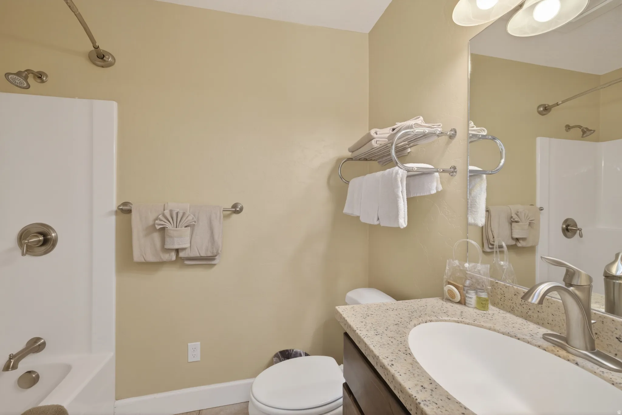 Bathroom vanity featuring a speckled countertop, undermount sink, and brushed nickel faucet
