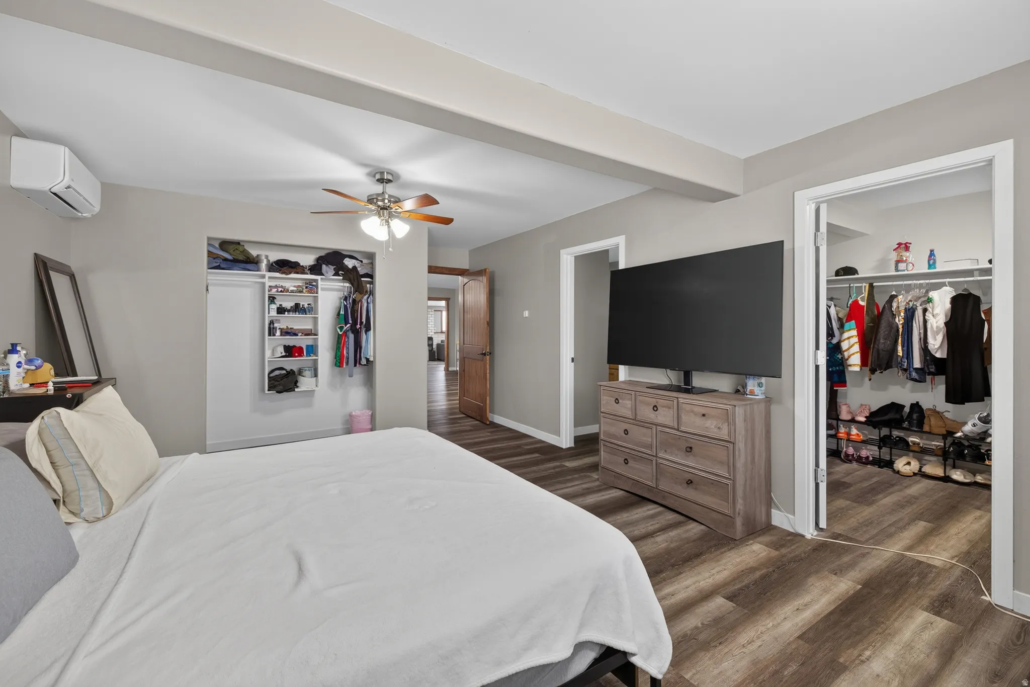 Bedroom with wood-finish flooring, a ceiling fan, and painted walls
