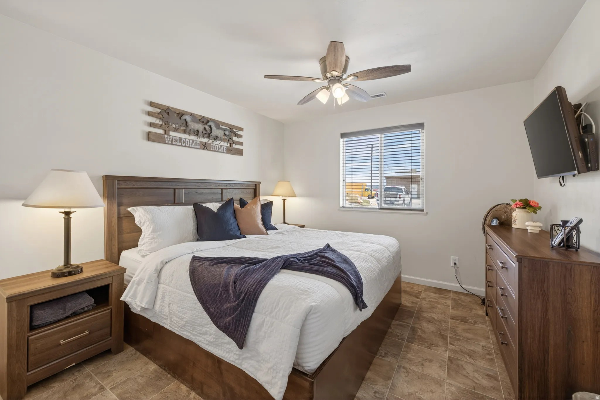 Neutral wall tones, wood-finish flooring, and a ceiling fan with integrated lighting
