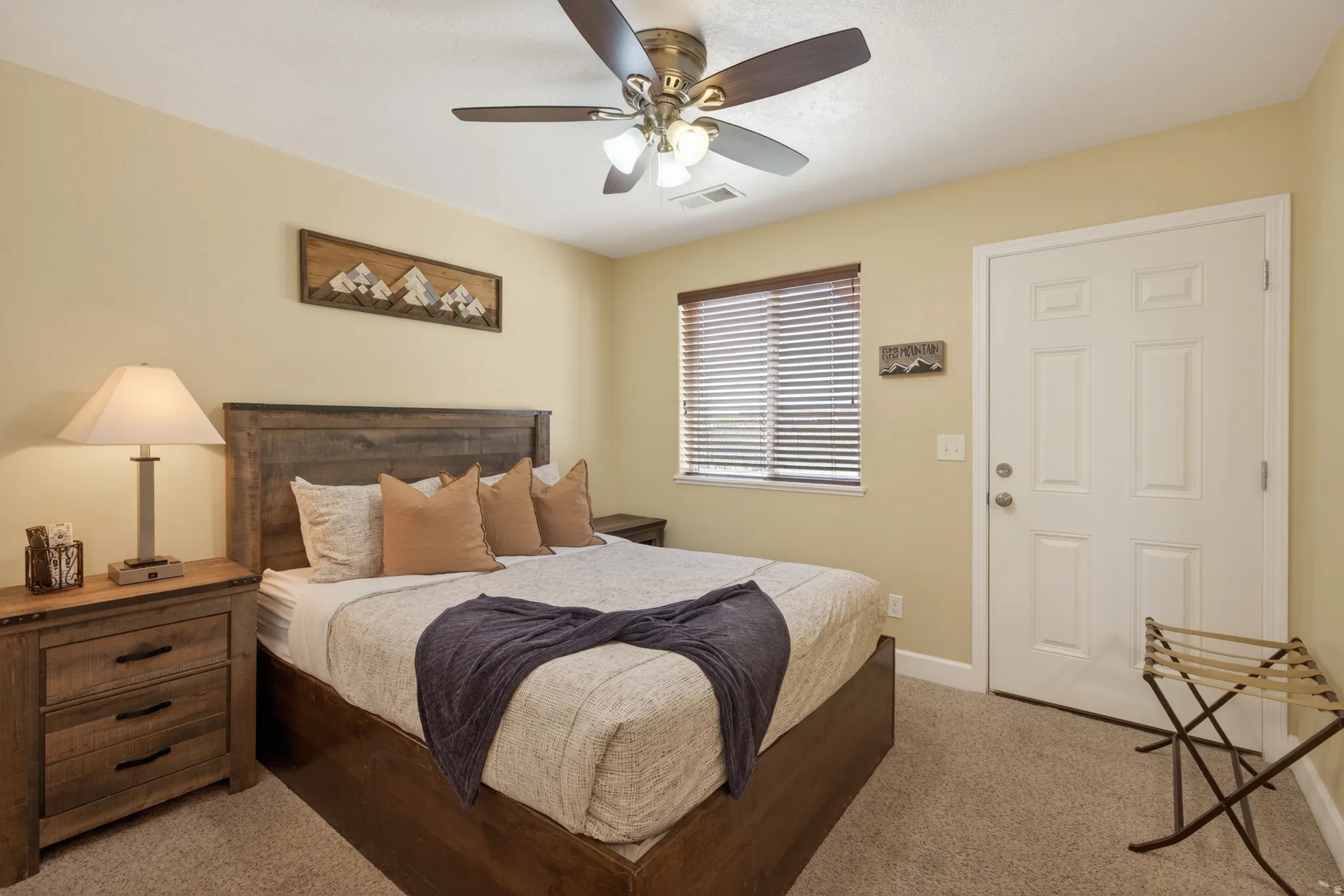 Bedroom featuring neutral-toned carpet flooring and a ceiling fan with integrated lighting
