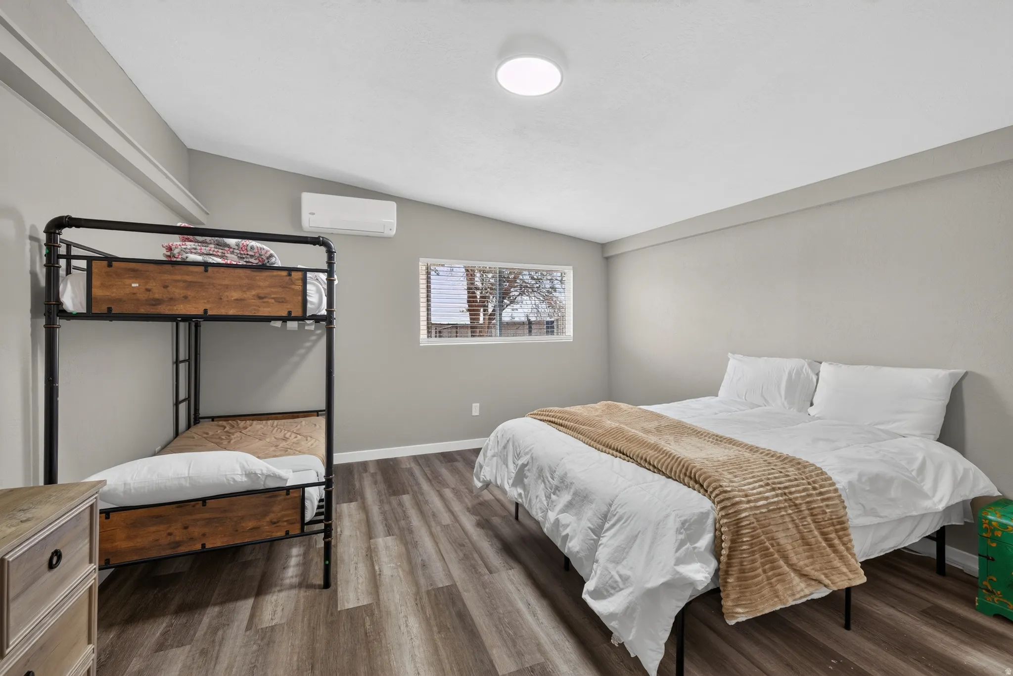 Interior space featuring wood-finish flooring, light gray wall paint, and a white ceiling with a flush-mount light fixture