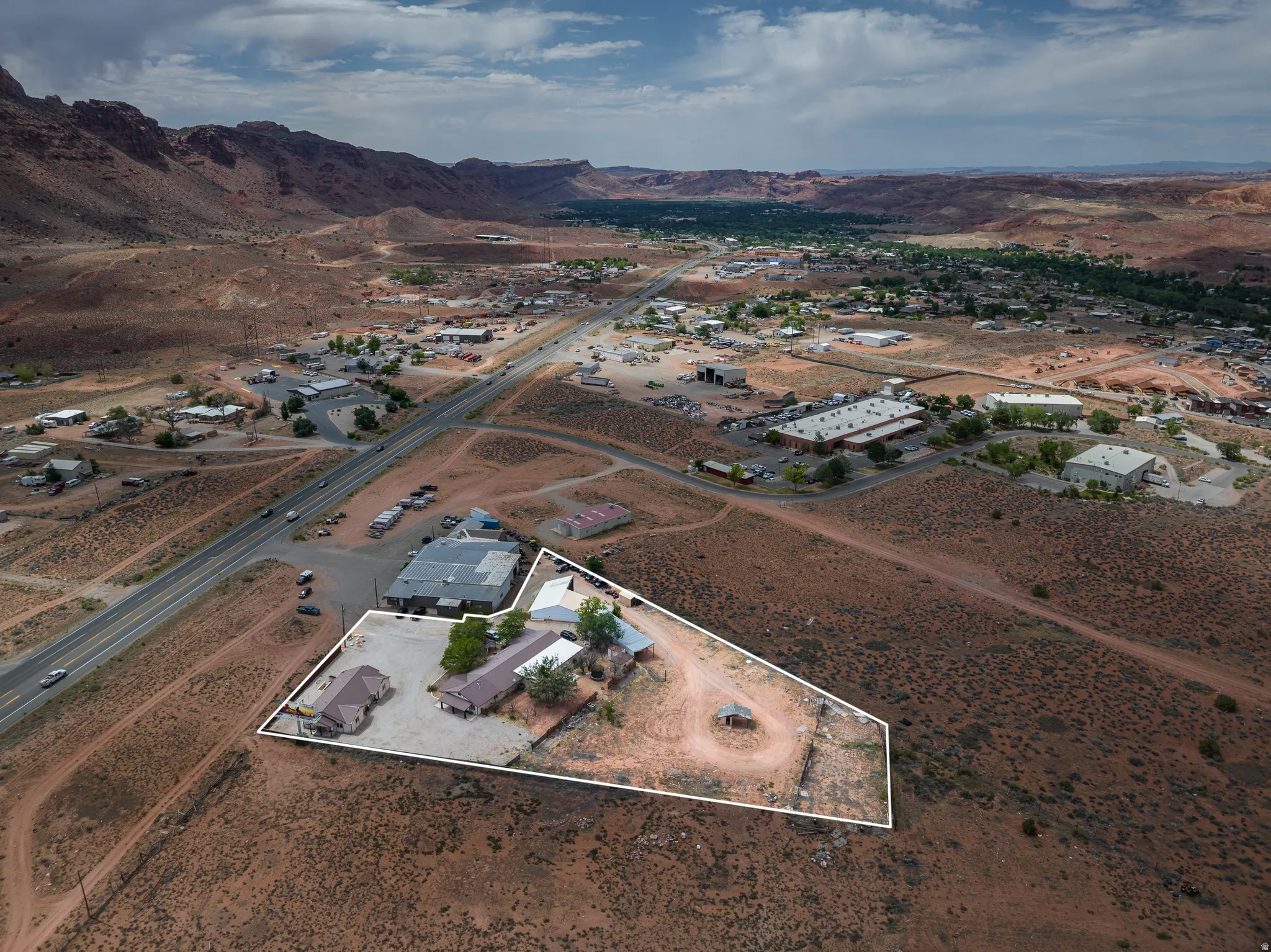 Expansive desert landscape with multiple buildings and direct road frontage