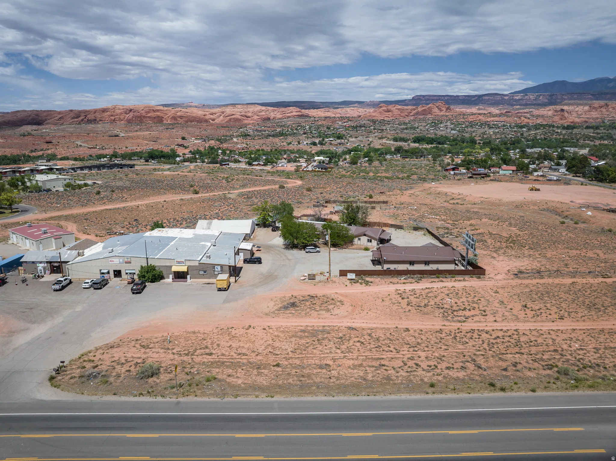 Expansive commercial property featuring multiple buildings with metal roofing and surrounding gravel areas