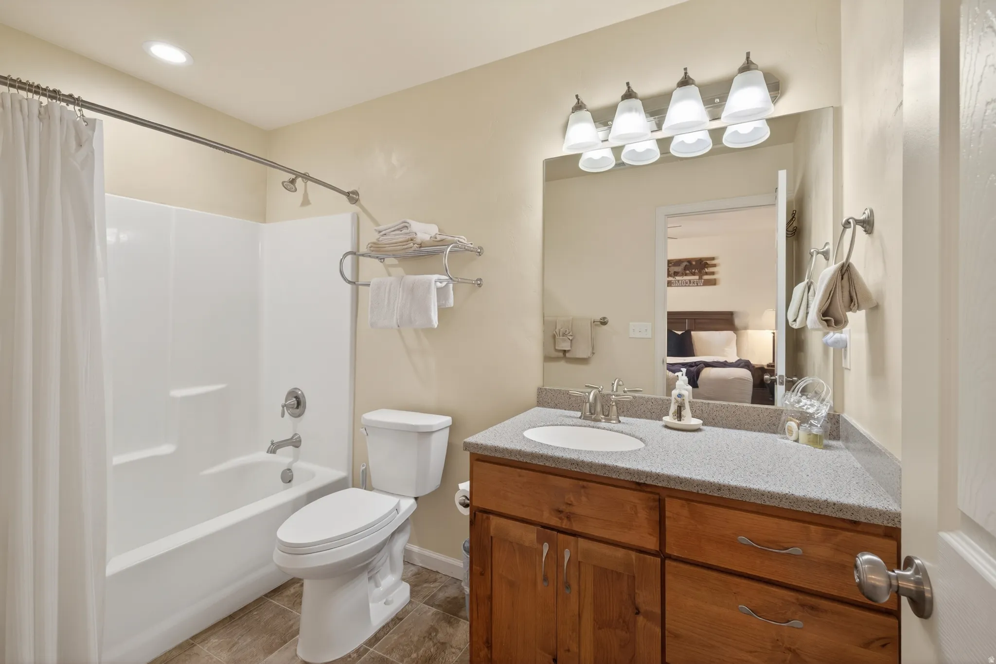 Bathroom vanity with a light-colored countertop, undermount sink, and wood-finish cabinetry