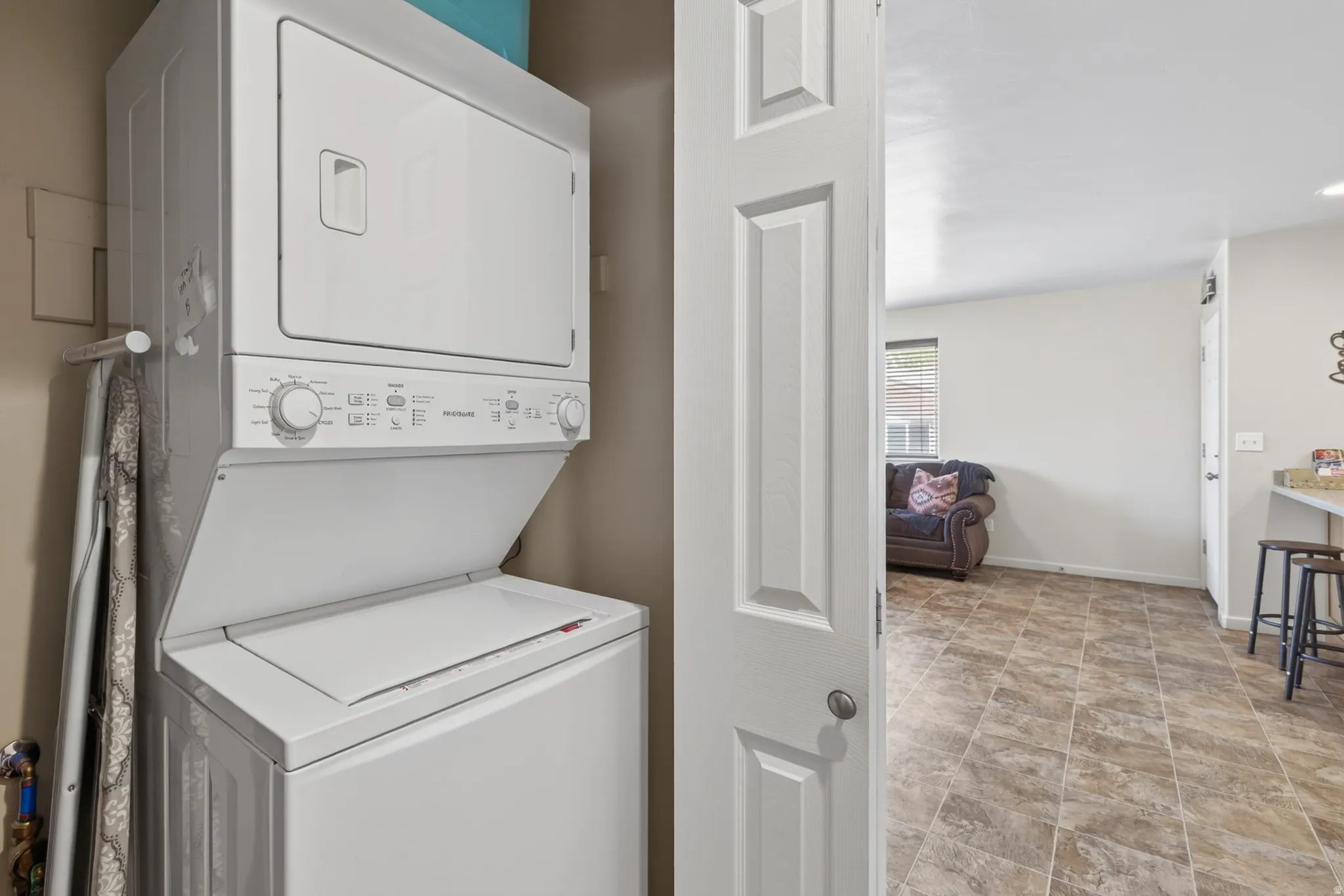 Dedicated laundry area featuring a stacked washer and dryer unit