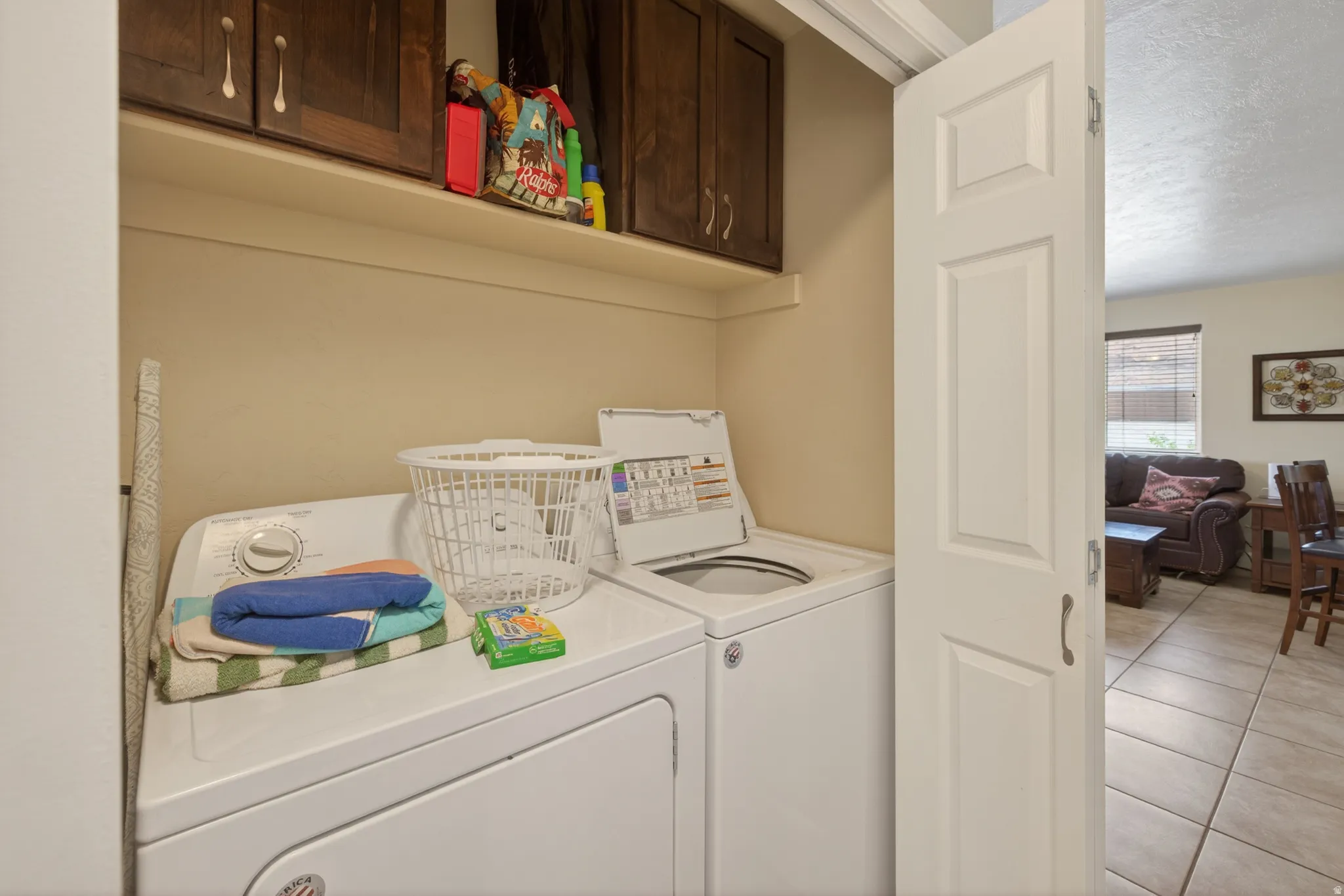 Dedicated laundry area featuring upper cabinetry and a shelf