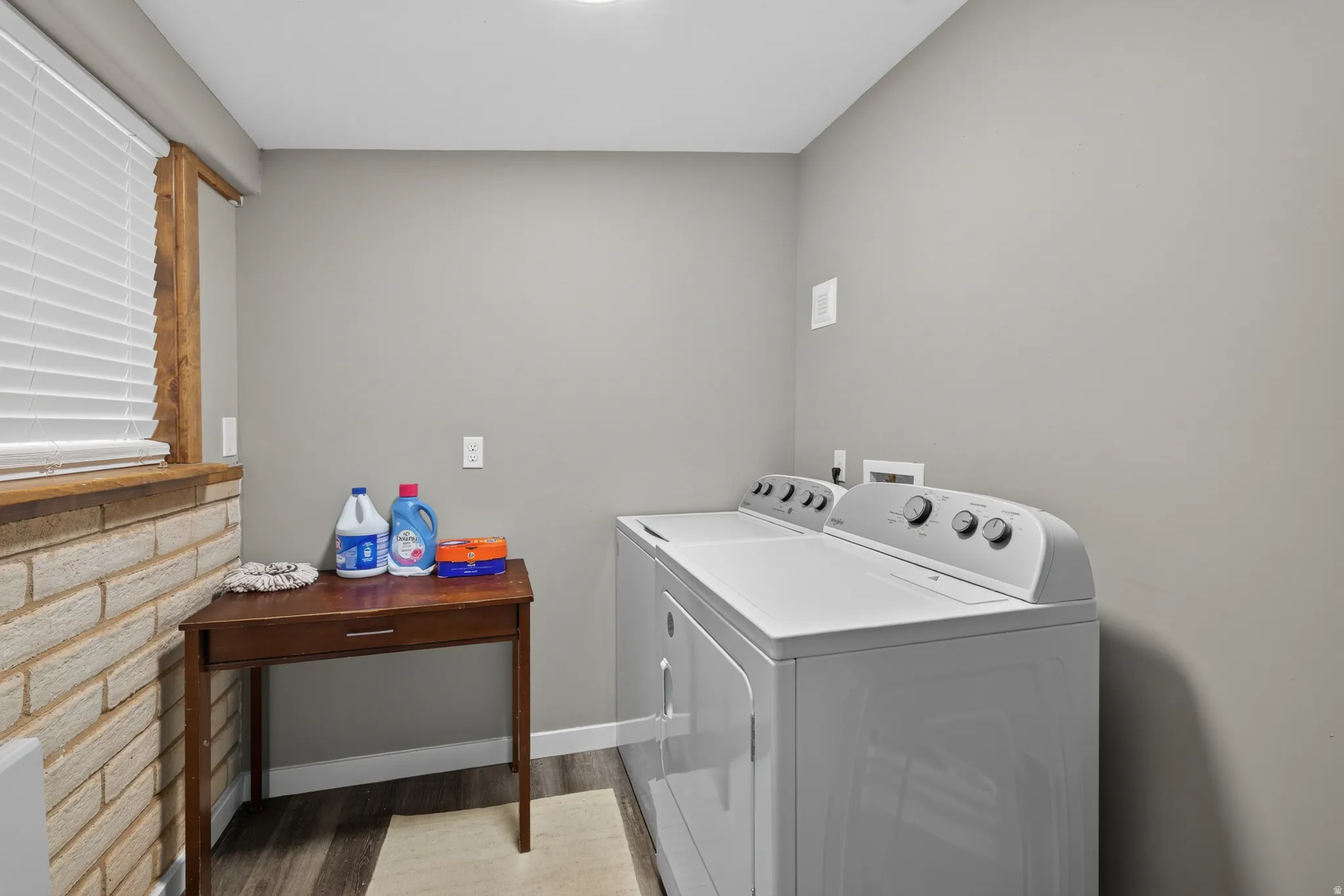 Dedicated laundry area featuring a washer and dryer, wood-finish flooring, and light gray walls