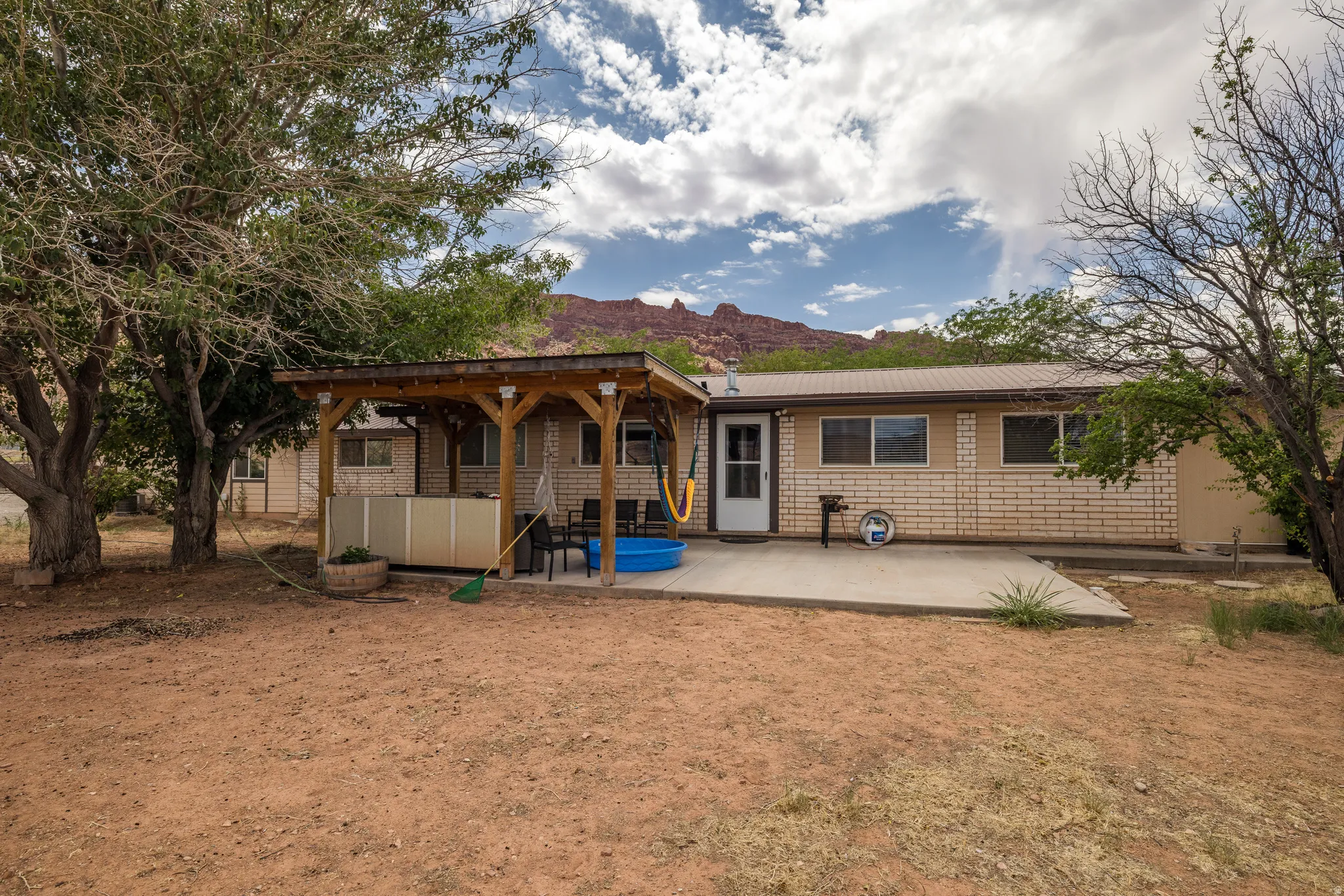 Exterior featuring a concrete patio, wood pergola, and metal roof
