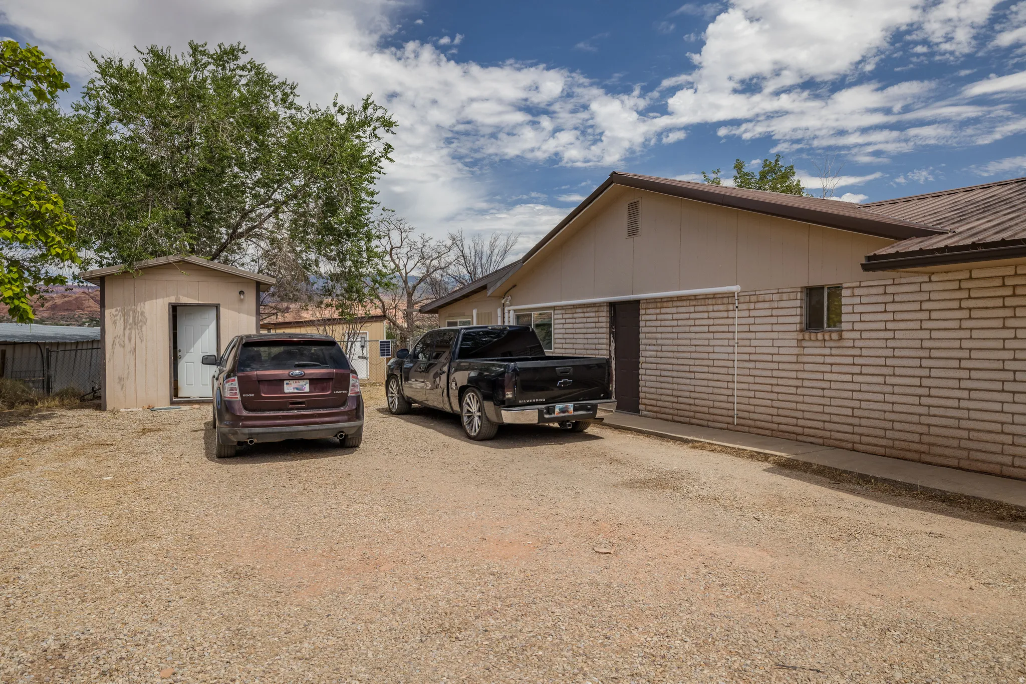 Expansive gravel parking area with a separate storage shed