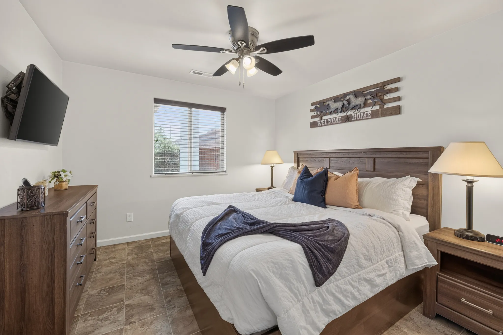 Interior room featuring wood-finish flooring, a ceiling fan with integrated lighting, and a window with horizontal blinds