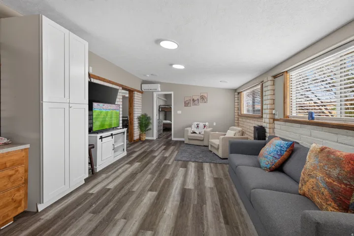 Spacious room featuring wood-finish flooring, recessed lighting, and white built-in cabinetry