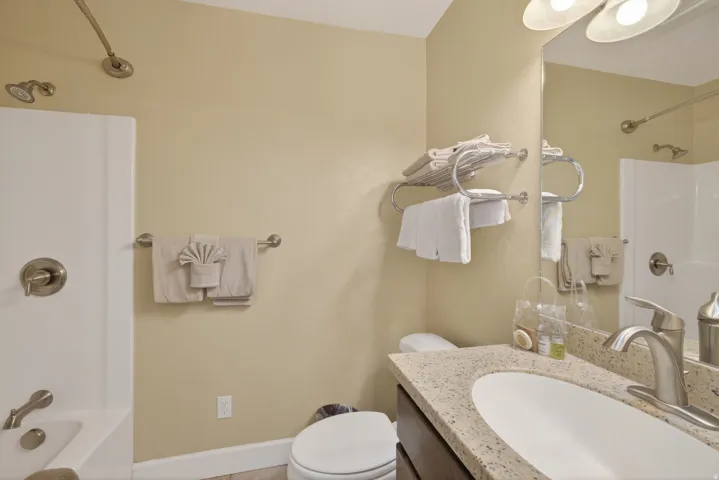 Bathroom vanity featuring a speckled countertop, undermount sink, and brushed nickel faucet