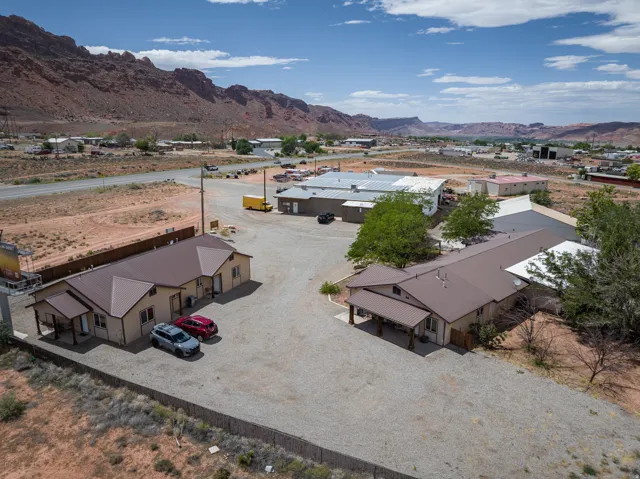 Expansive gravel lot featuring multiple buildings with metal roofs and covered entrances