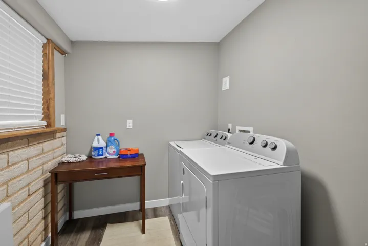 Dedicated laundry area featuring a washer and dryer, wood-finish flooring, and light gray walls