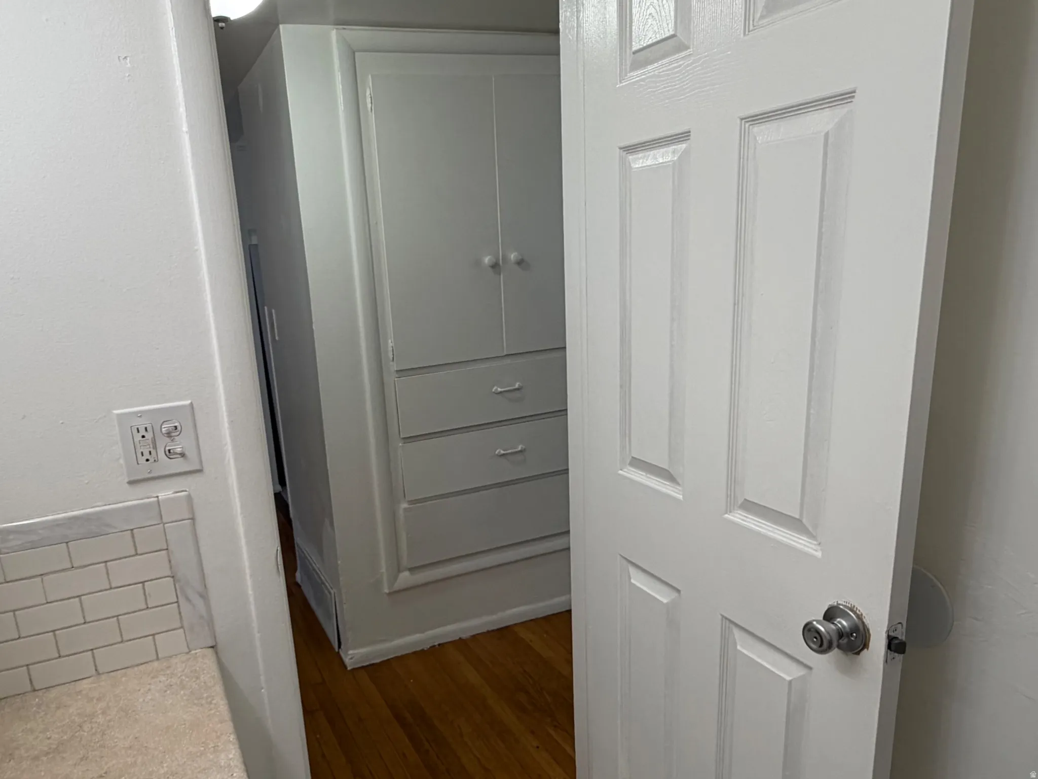 Hallway with built-in storage and wood floors