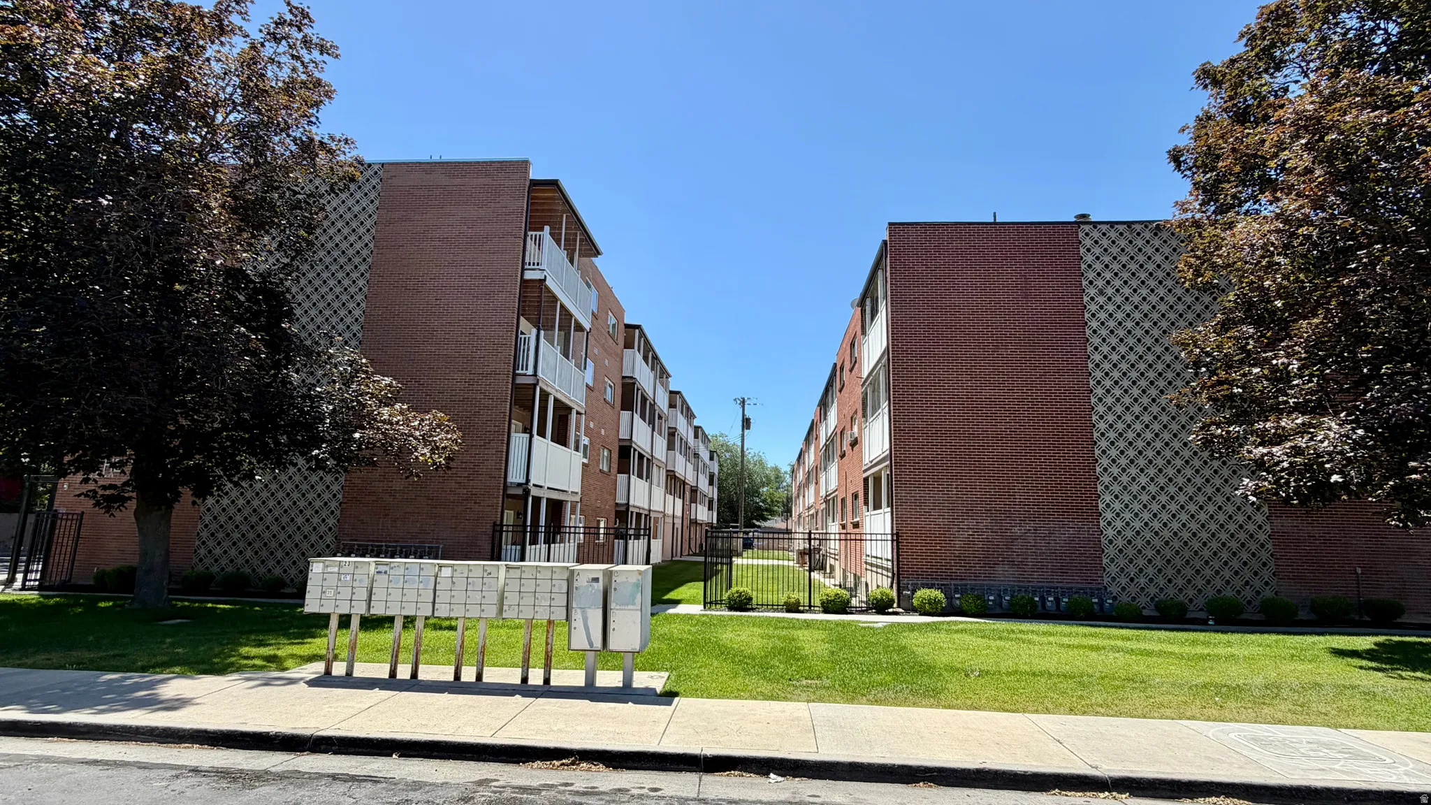 Exterior brick facade building featuring private balconies, and secured postal boxes