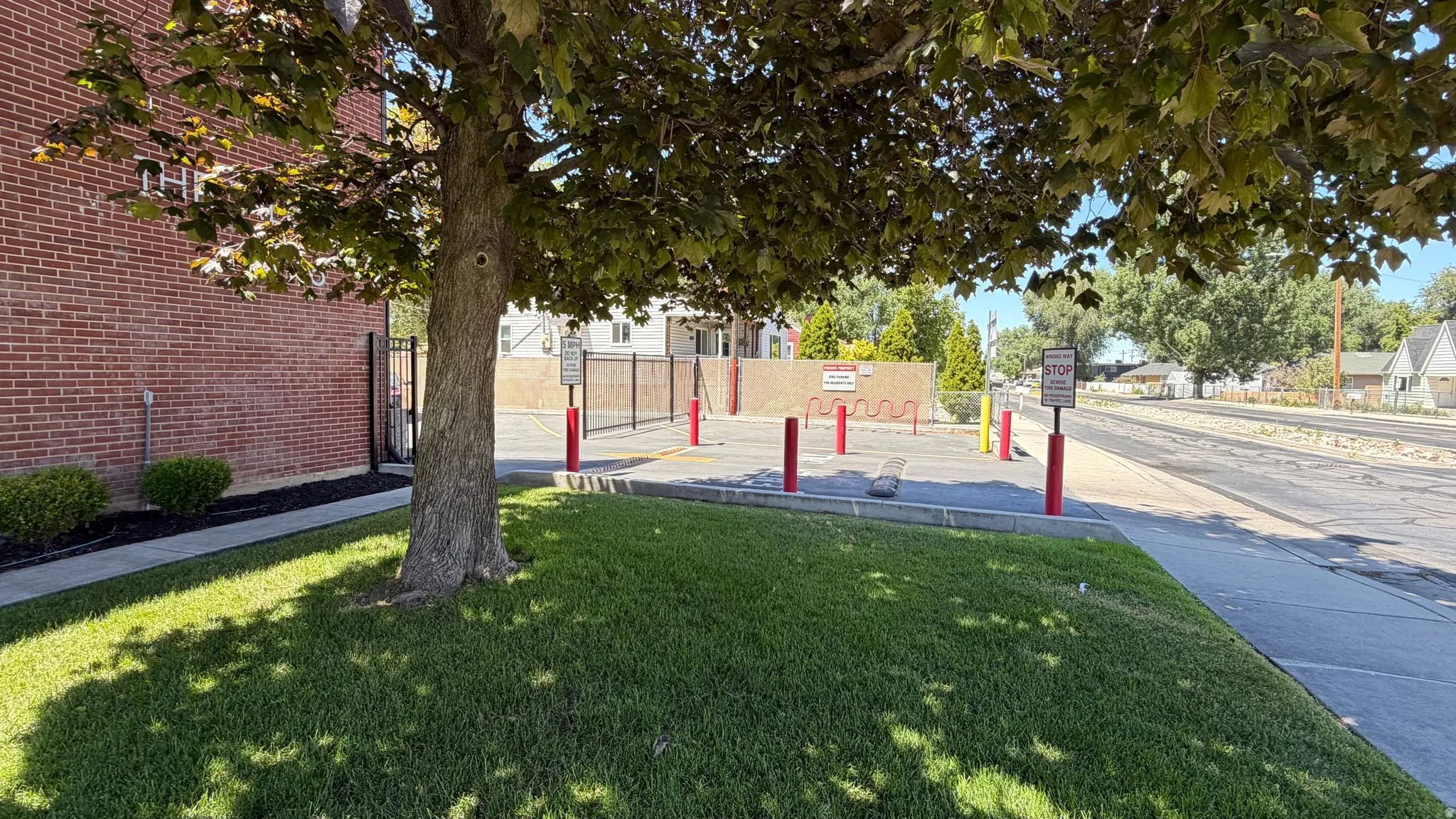 Gated parking area with bicycle storage, mature trees and full landscaping