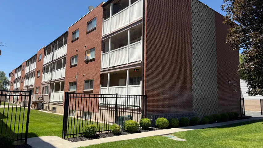 Brick exterior building featuring multiple private balconies and a central courtyard