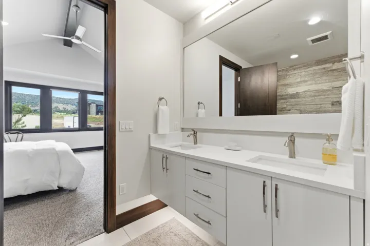 Dual vanity with integrated rectangular sinks, brushed nickel faucets, and white cabinetry with coordinating hardware