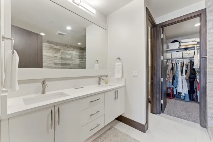 Dual vanity with integrated sinks, brushed nickel fixtures, and white cabinetry