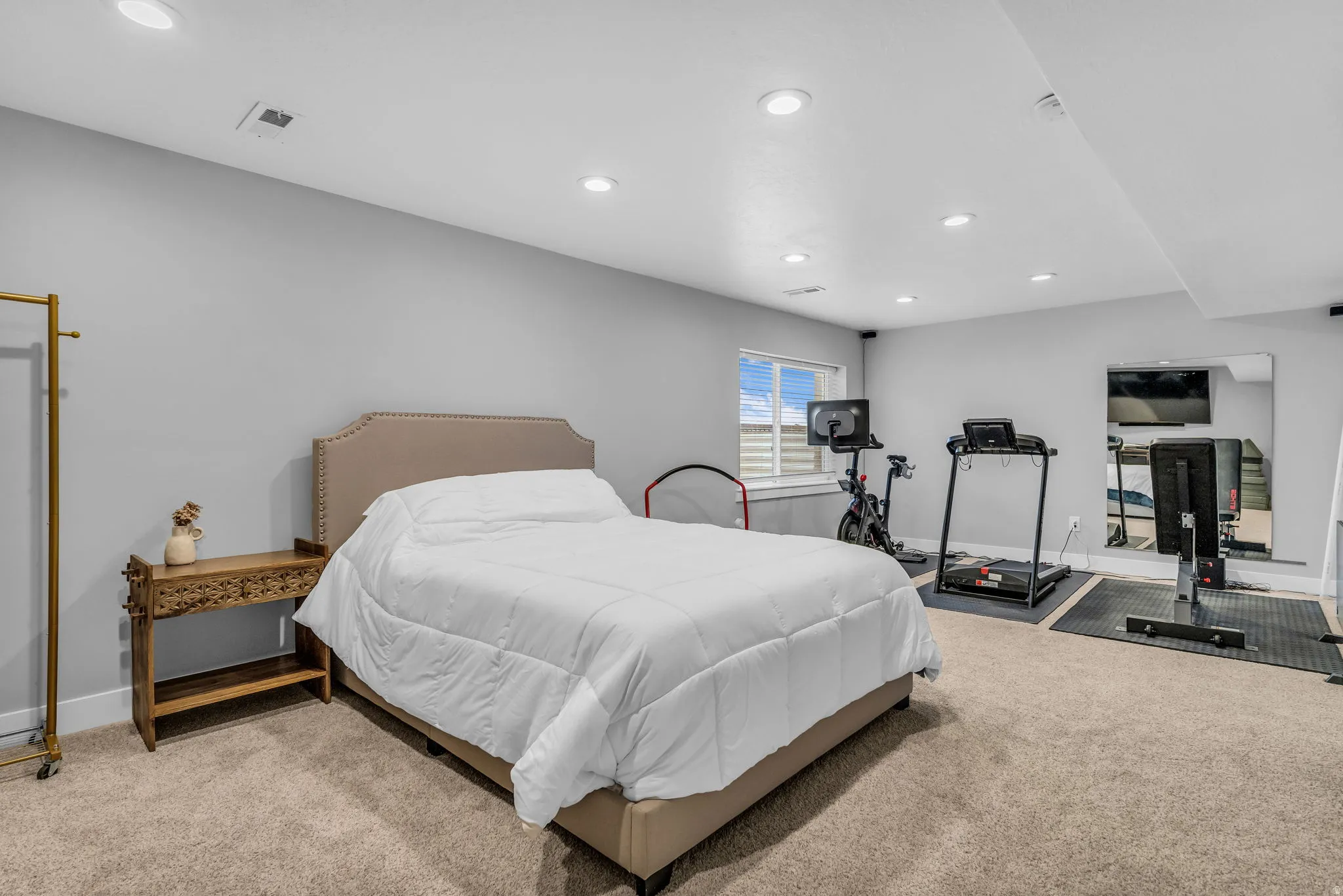 Carpeted room with recessed lighting and a window
