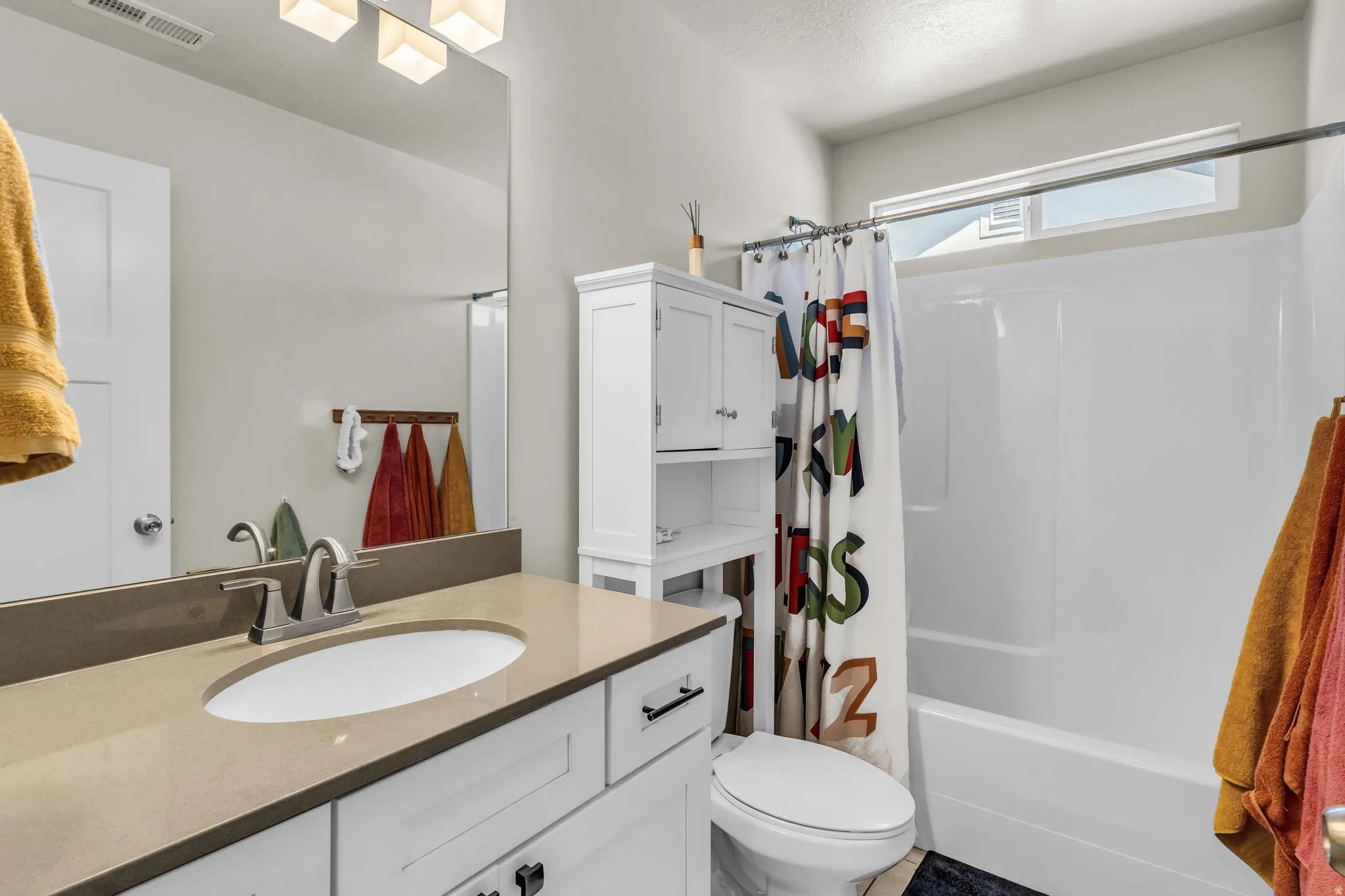 Bathroom featuring a white vanity with a light-toned countertop, an undermount sink, and a chrome faucet