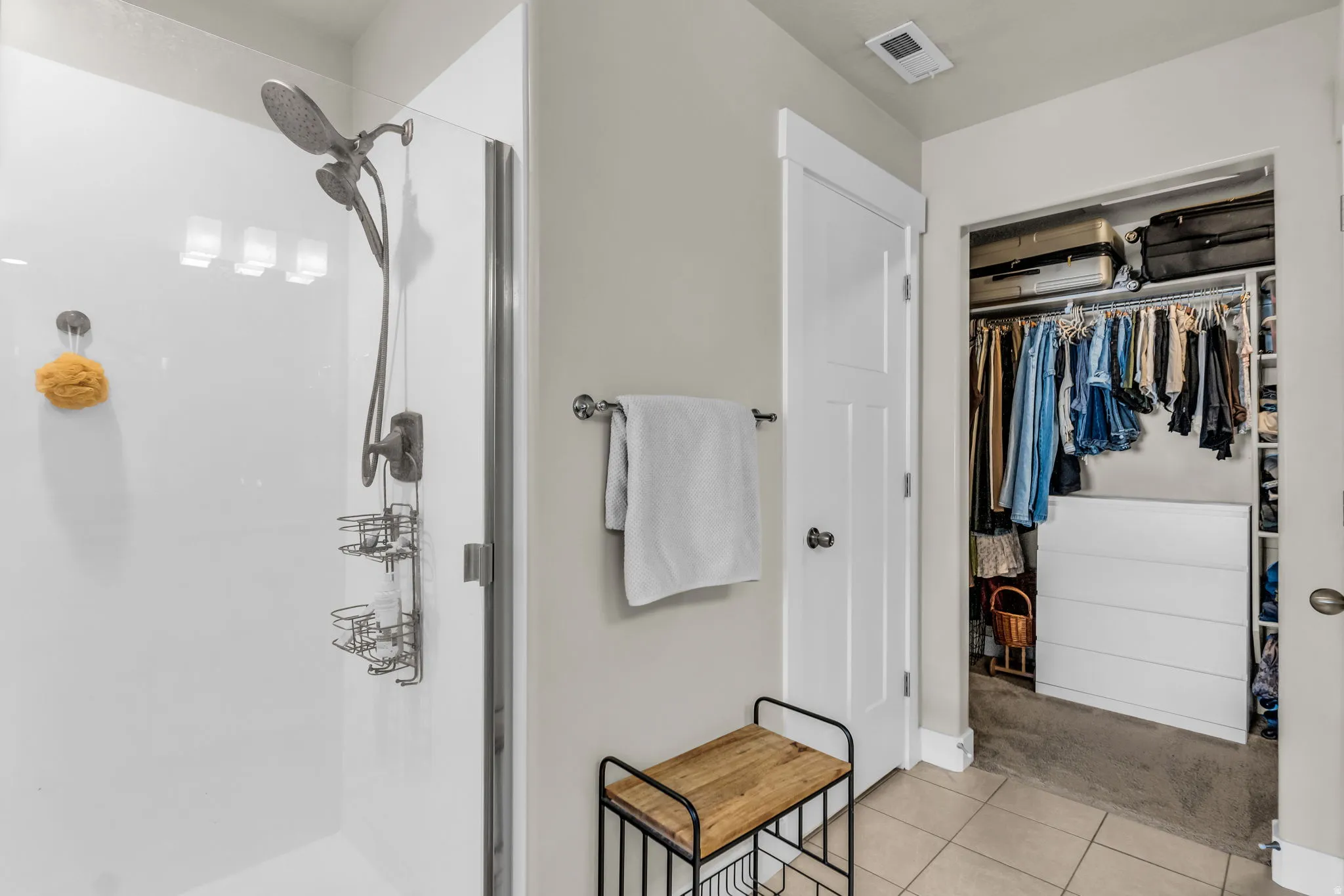 Walk-in shower with a glass enclosure and brushed nickel fixtures