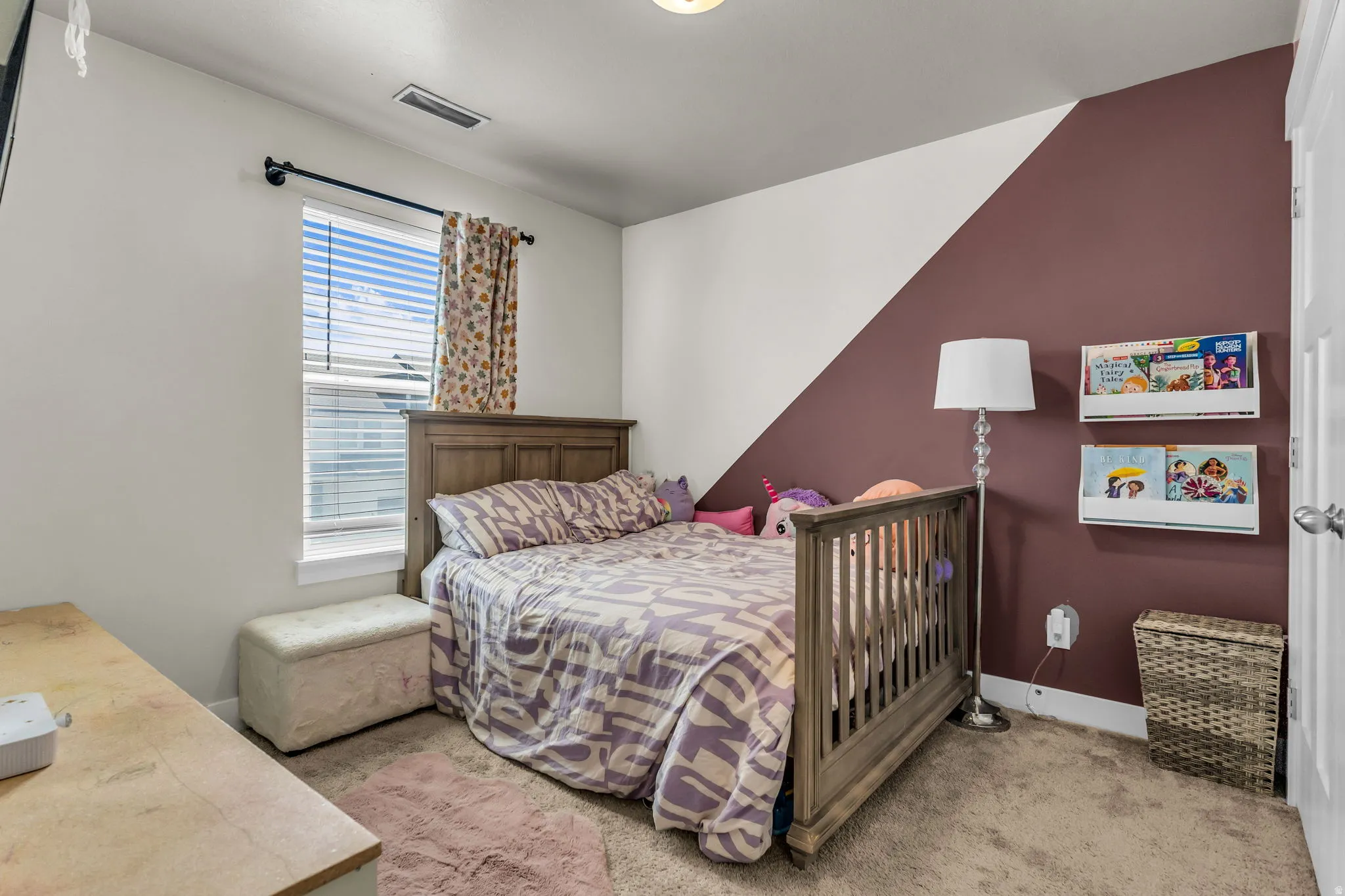 Bright room featuring a window with blinds, carpeted flooring, and a unique two-tone wall design