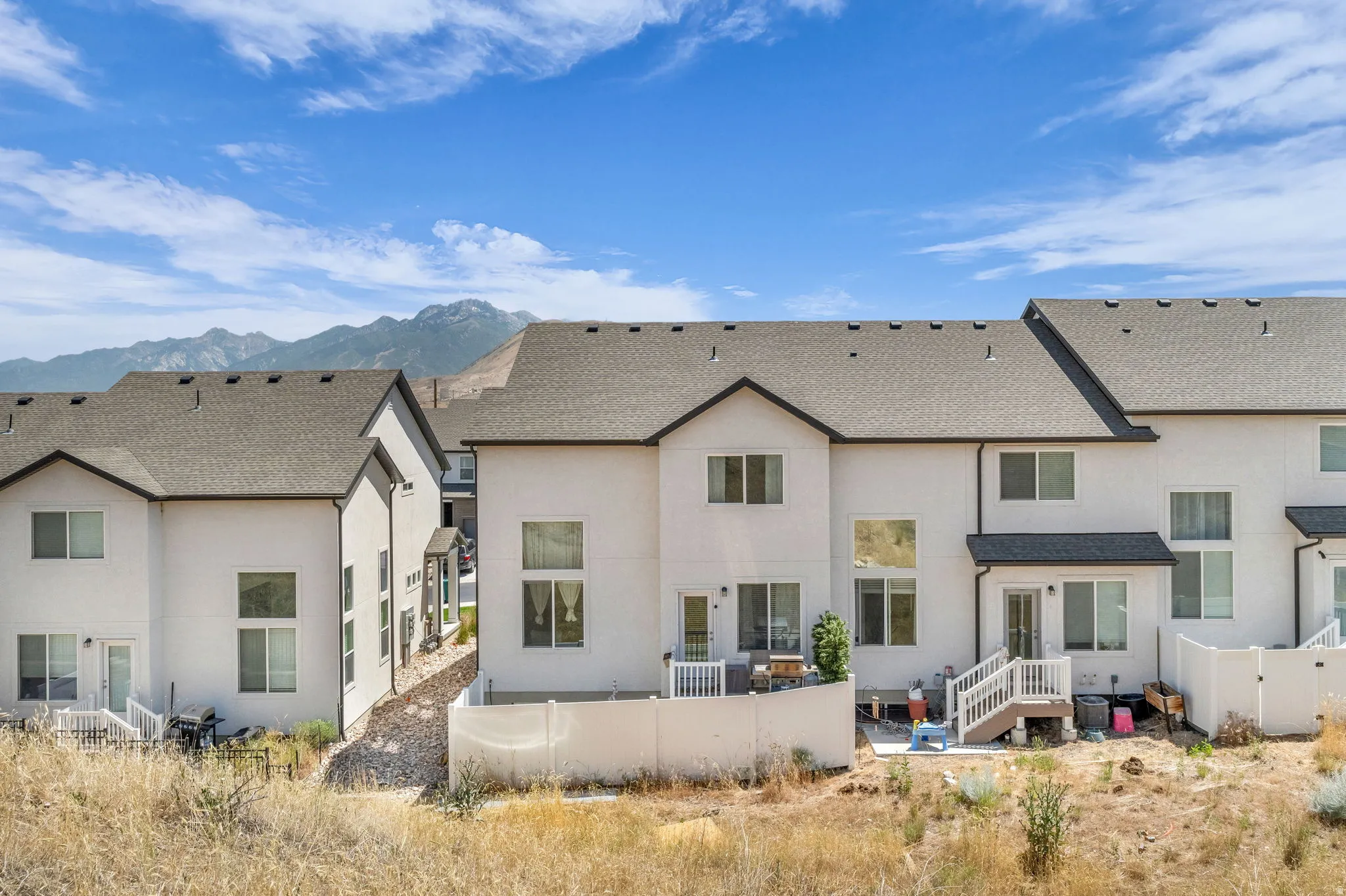 Exterior of contemporary townhomes featuring stucco siding and dark shingle roofs