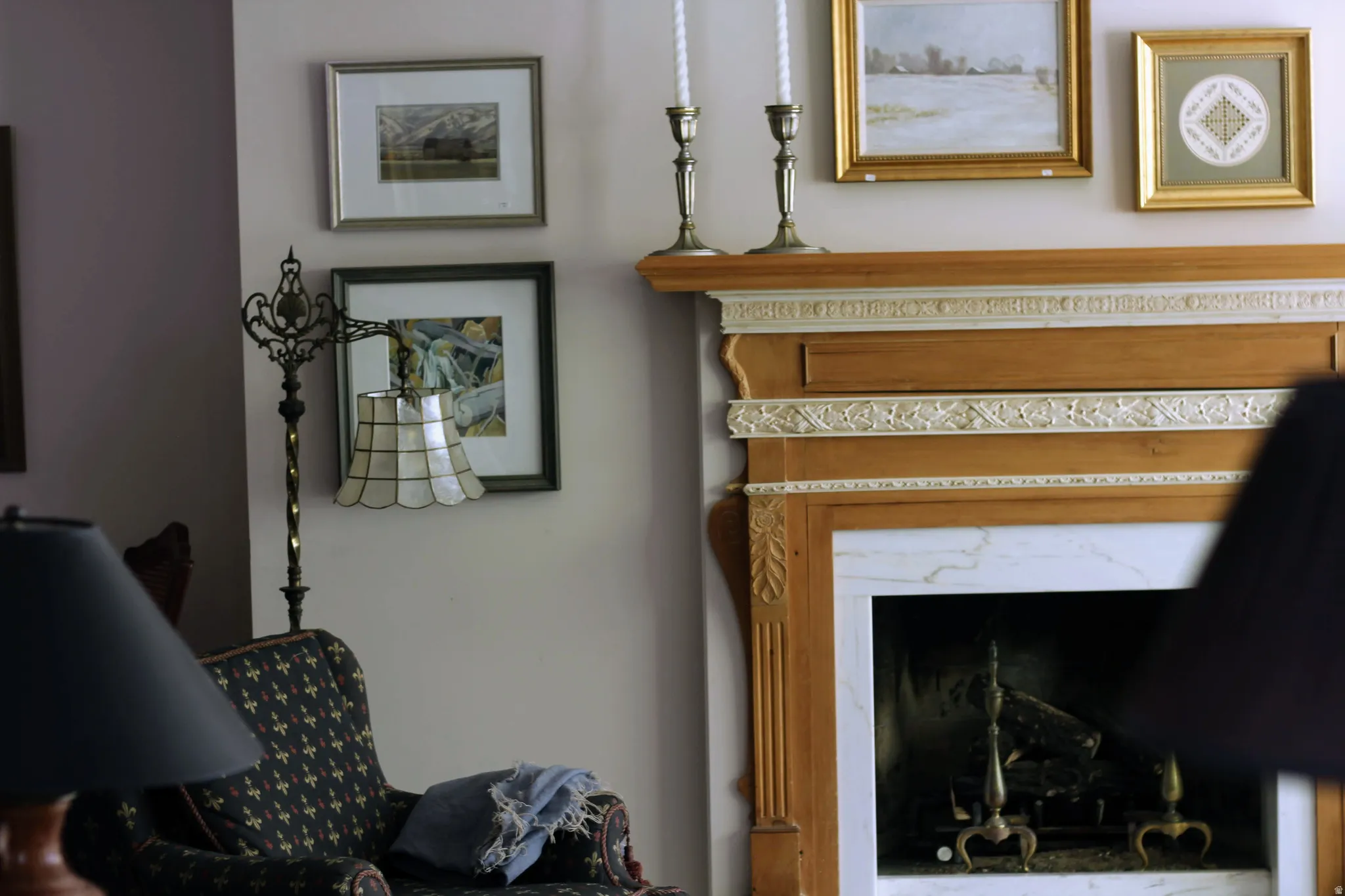 Traditional wood fireplace mantel with intricate carved detailing and a white marble surround