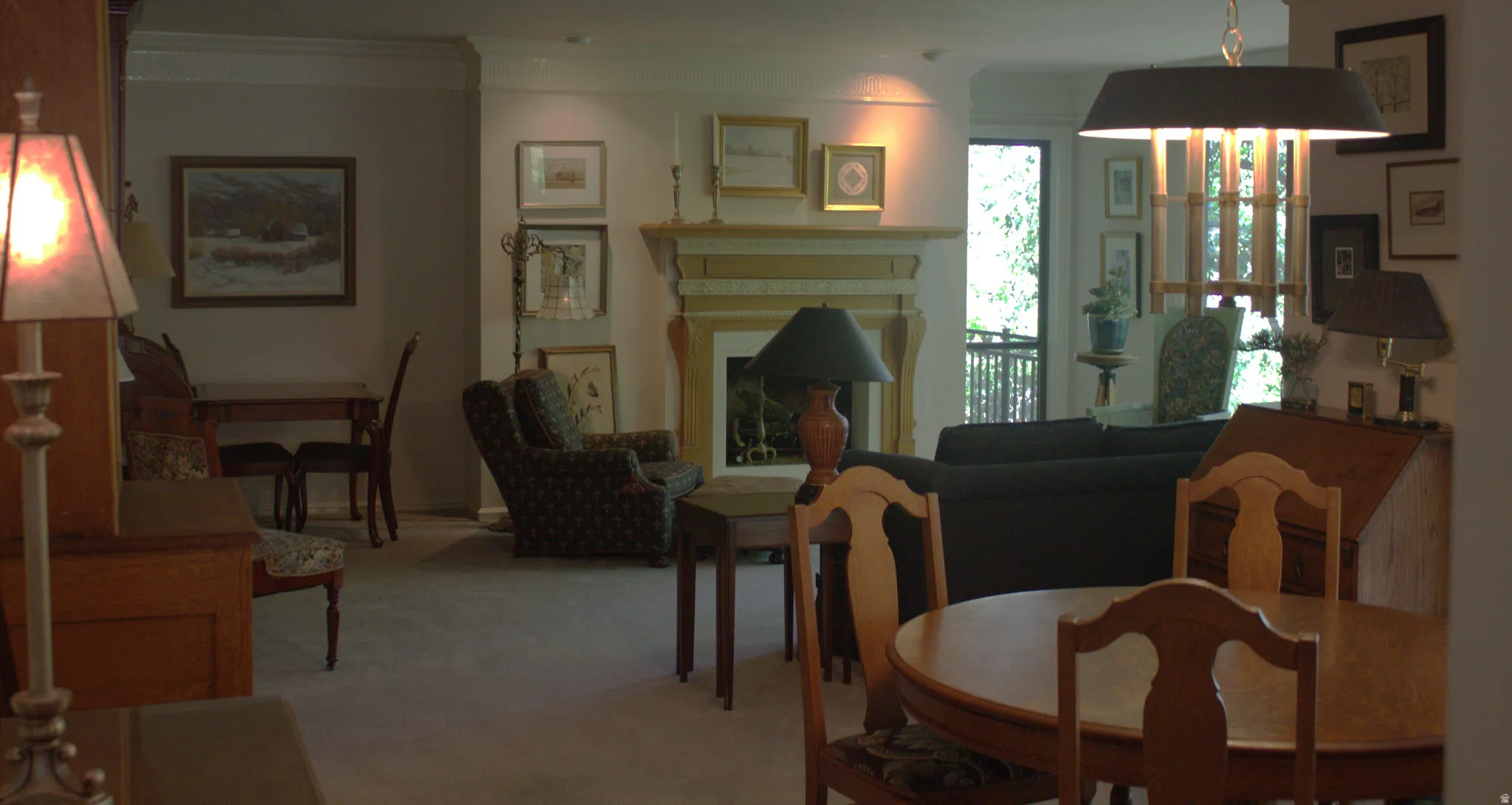 Living area featuring a fireplace with a decorative mantel, light-colored walls, and a large window providing natural light