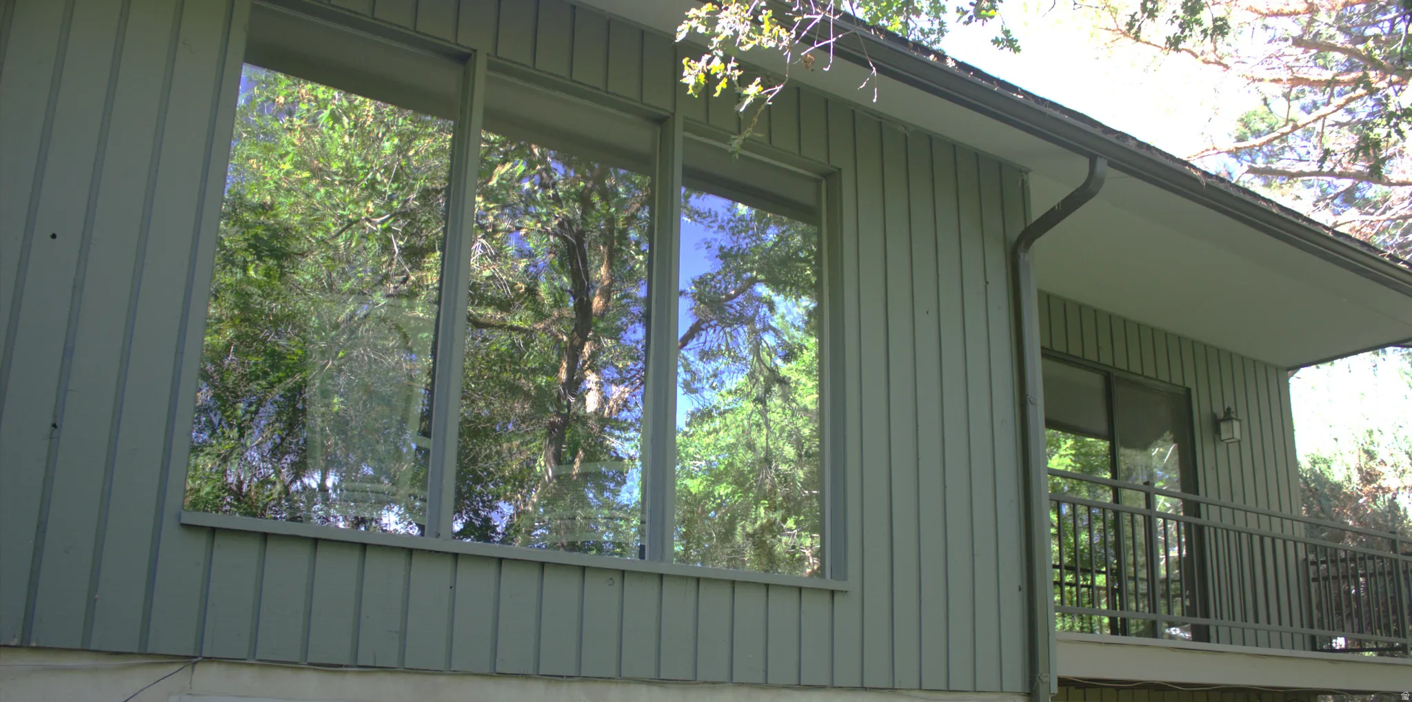Exterior featuring vertical siding and a continuous band of windows