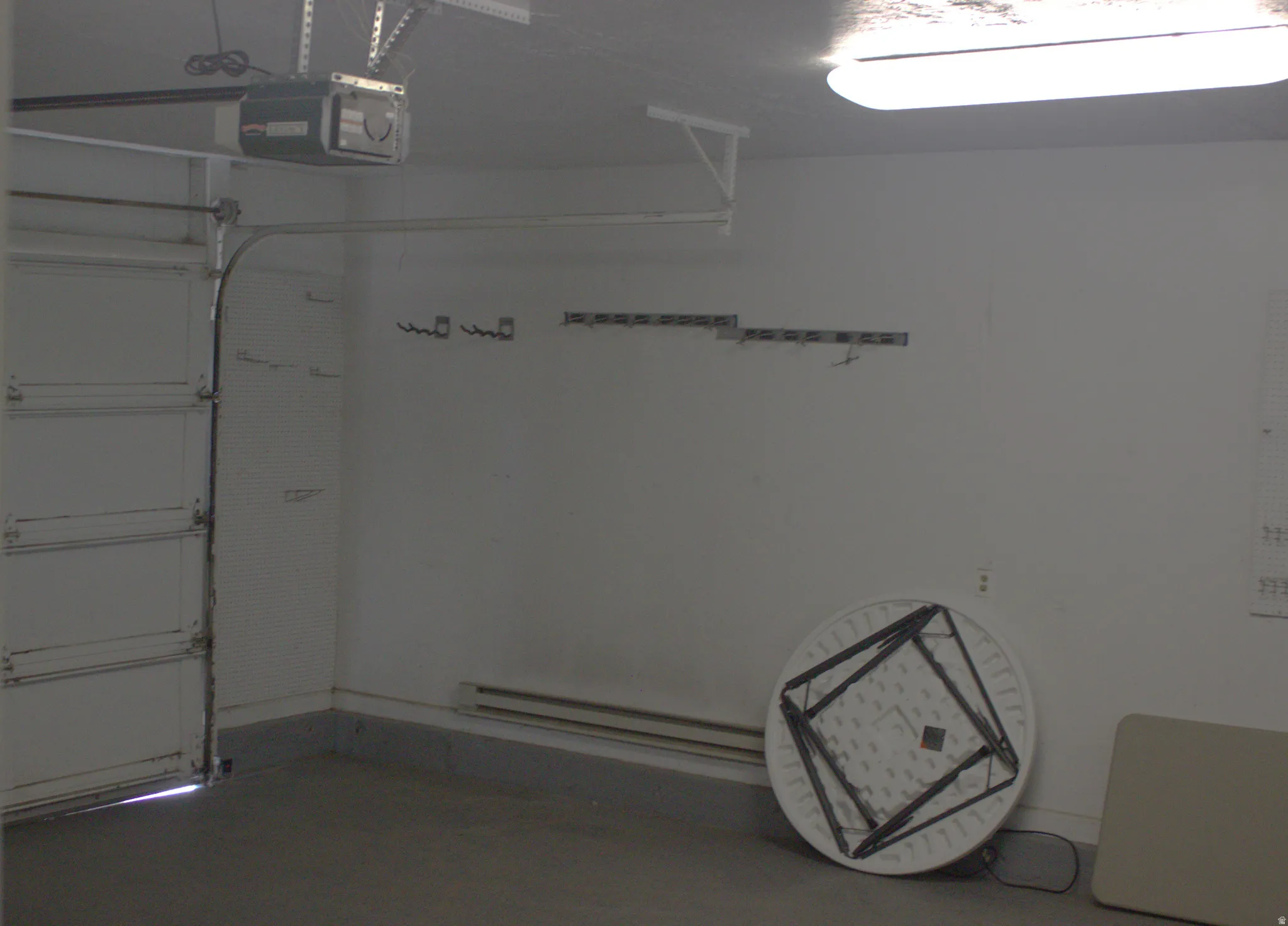 Attached garage featuring a concrete floor and a white paneled garage door with an automatic opener