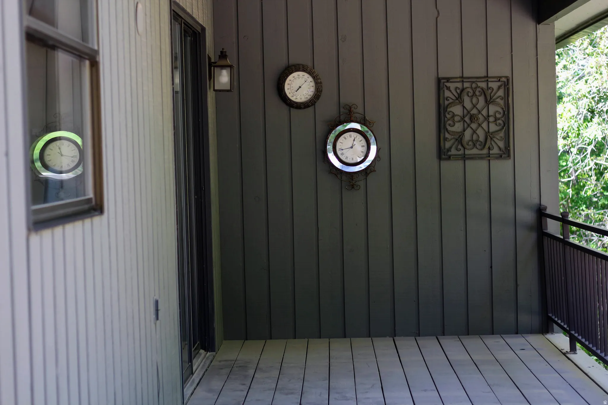 Covered porch featuring vertical wood siding and plank flooring