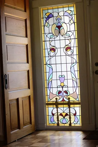 Ornate stained-glass sidelight with decorative metal grillwork