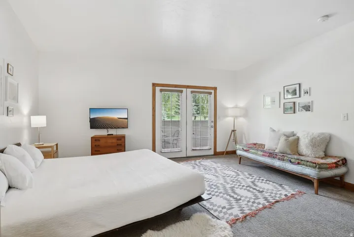 Light-filled room featuring double French doors with exterior access, wood-finish trim, and recessed lighting