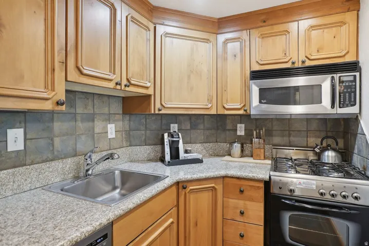 Corner kitchen with wood cabinetry and light-colored countertops
