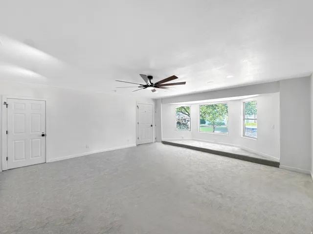 Spacious interior featuring light gray carpeting and white walls