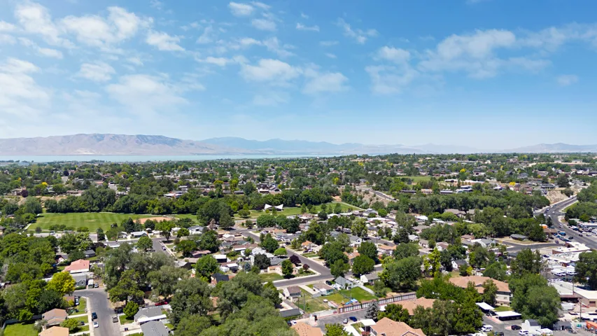 Expansive aerial perspective showcasing a residential area with mature trees, established streets, and varied property types