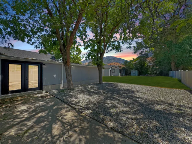 Backyard featuring a concrete patio, gravel area, and a grassy expanse