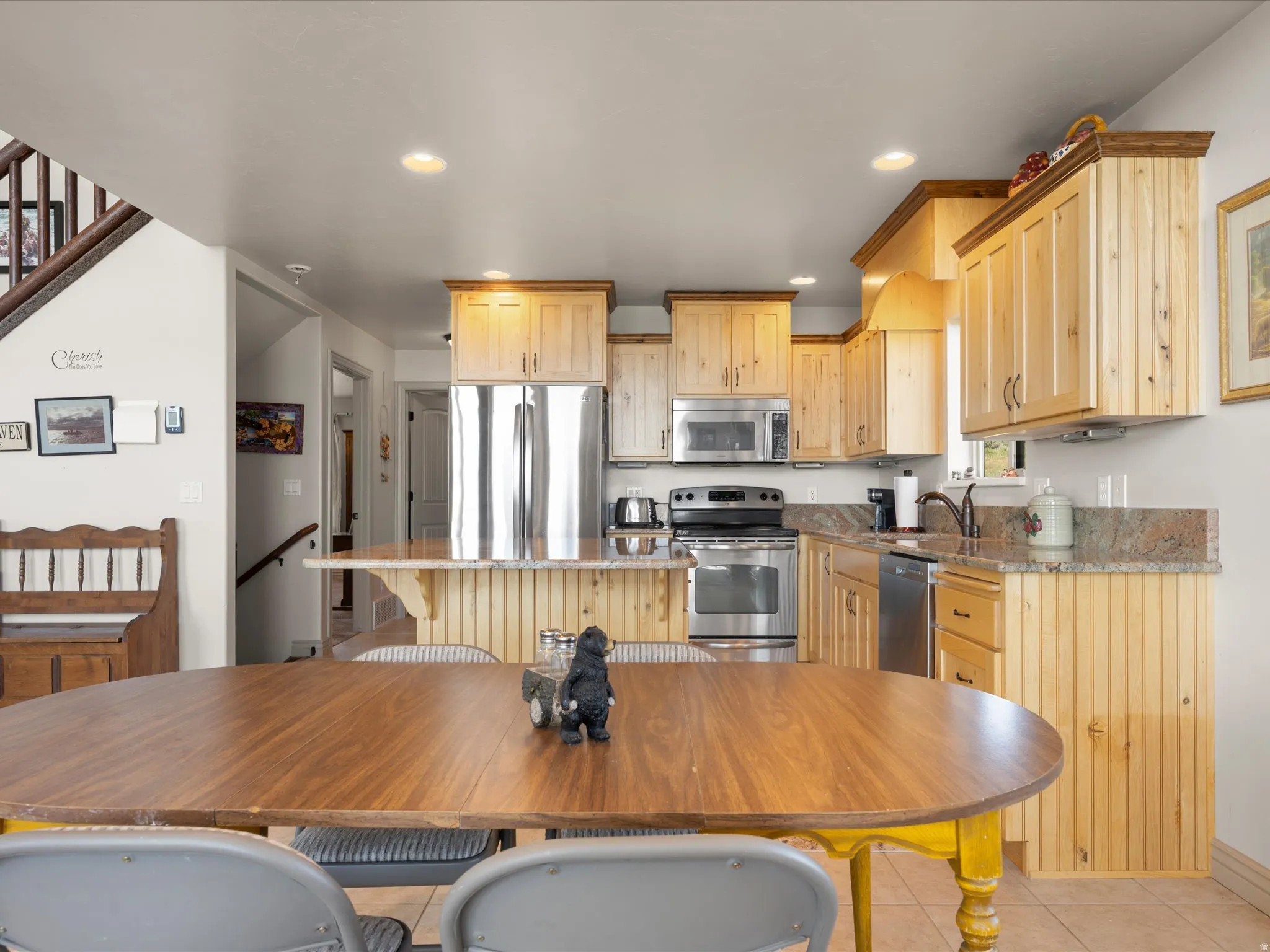 Kitchen featuring natural wood-finish cabinetry, granite-style countertops, and stainless steel appliances