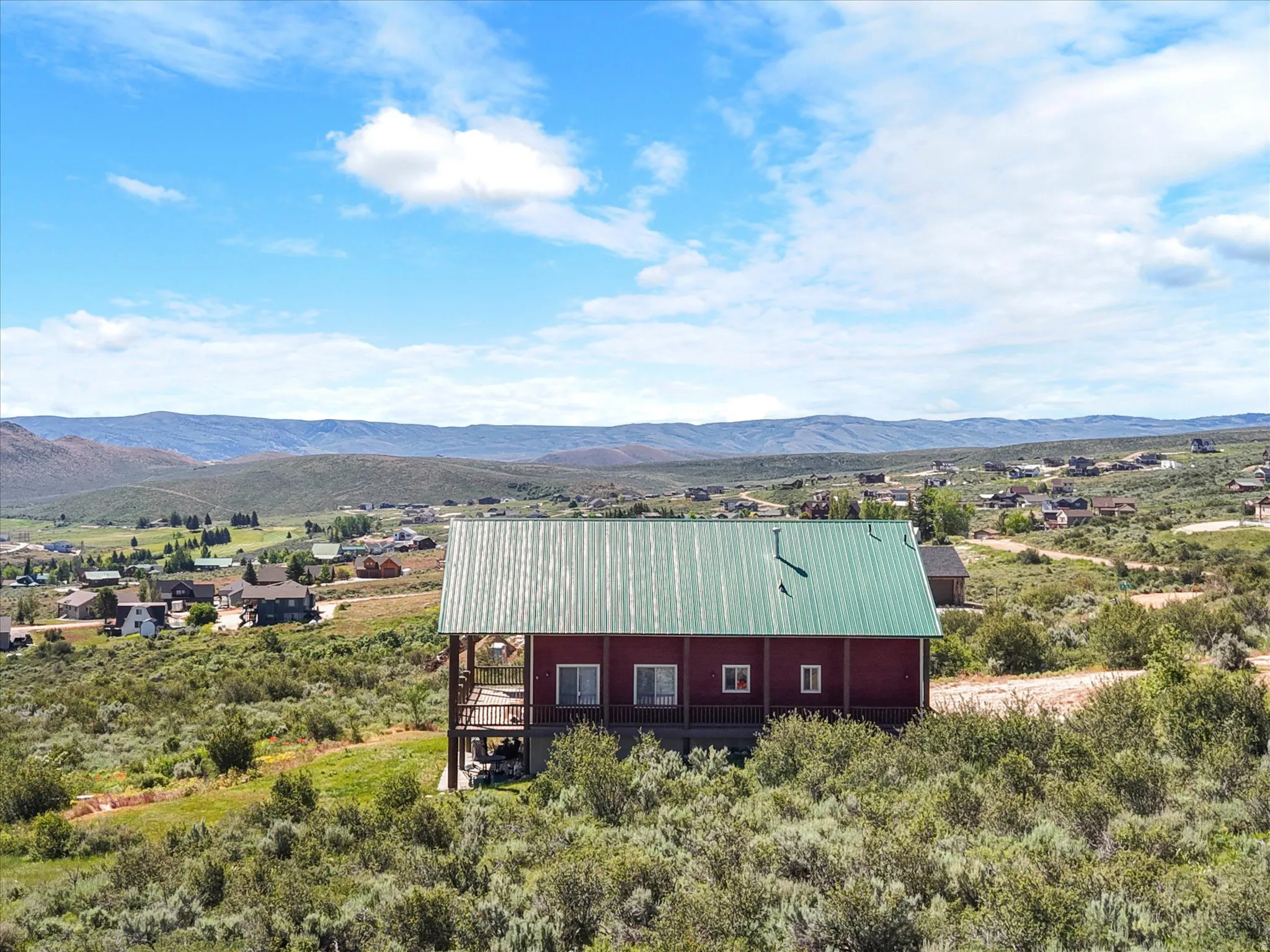 Two-story residence with a green metal roof and red siding