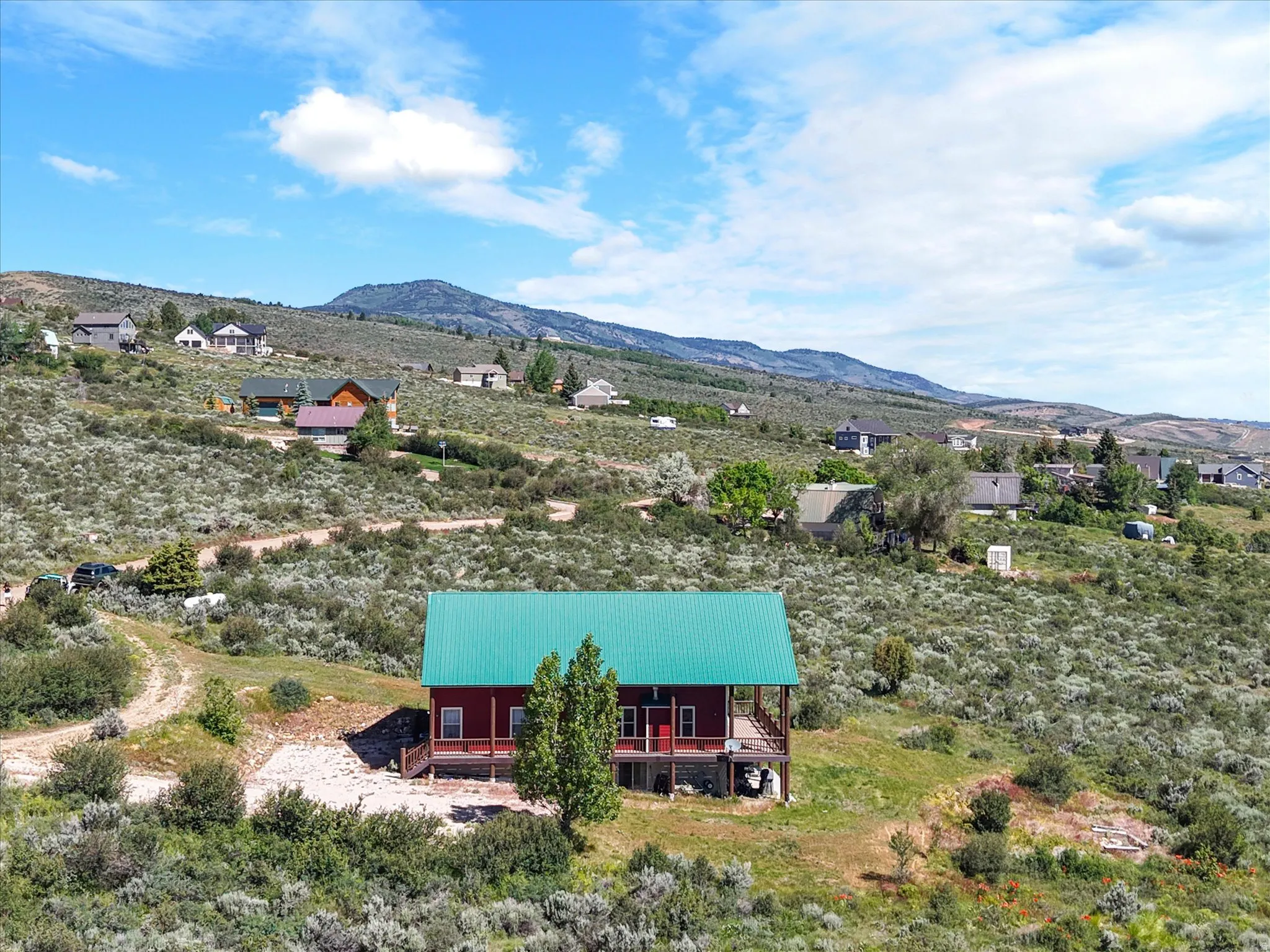 Red exterior home with a vibrant green metal roof