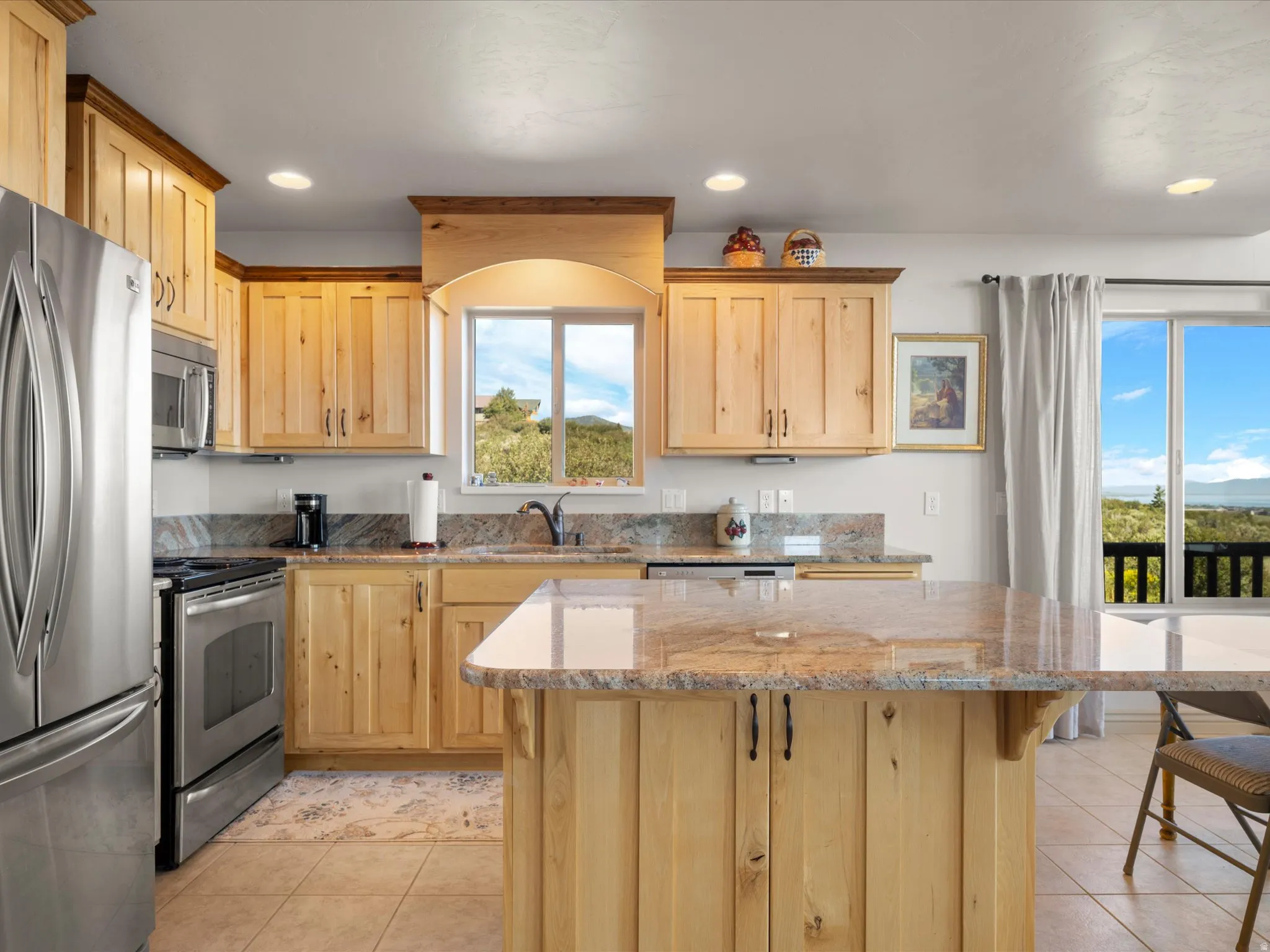 Kitchen featuring light wood cabinetry, stone countertops, stainless steel appliances, recessed lighting, and tile flooring