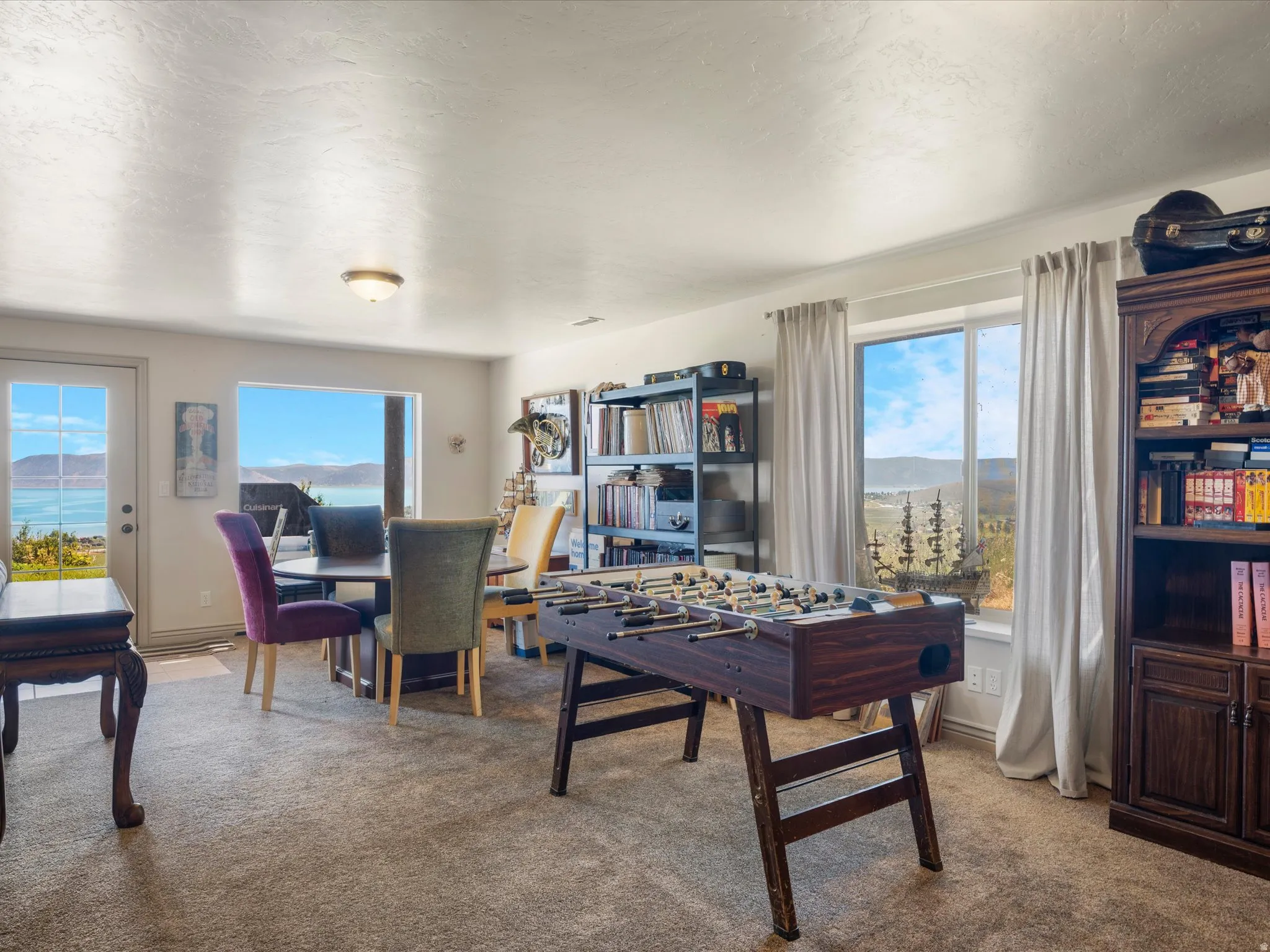 Spacious room featuring carpeting, large windows, recessed lighting, and a glass-paneled exterior door