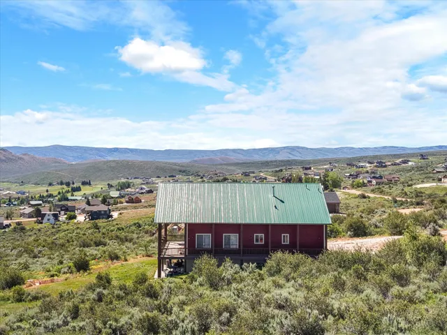 Two-story residence with a green metal roof and red siding