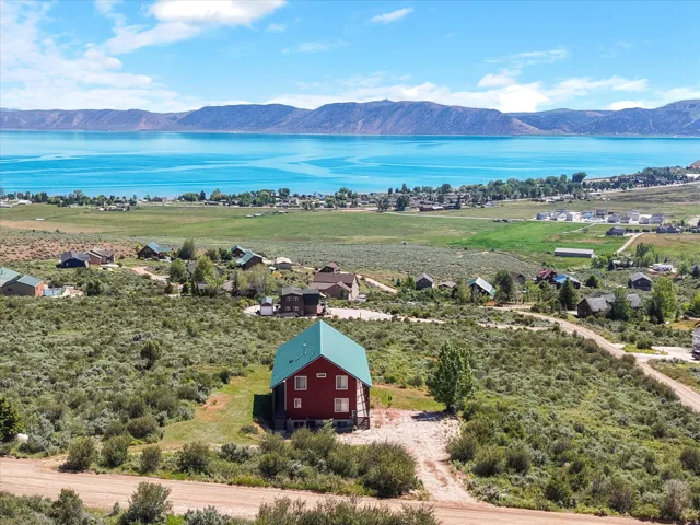 Exterior residence with a green metal roof, view of water and mountains