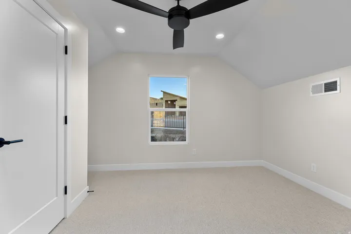 Room featuring vaulted ceilings, recessed lighting, a ceiling fan, carpet flooring, and a single window